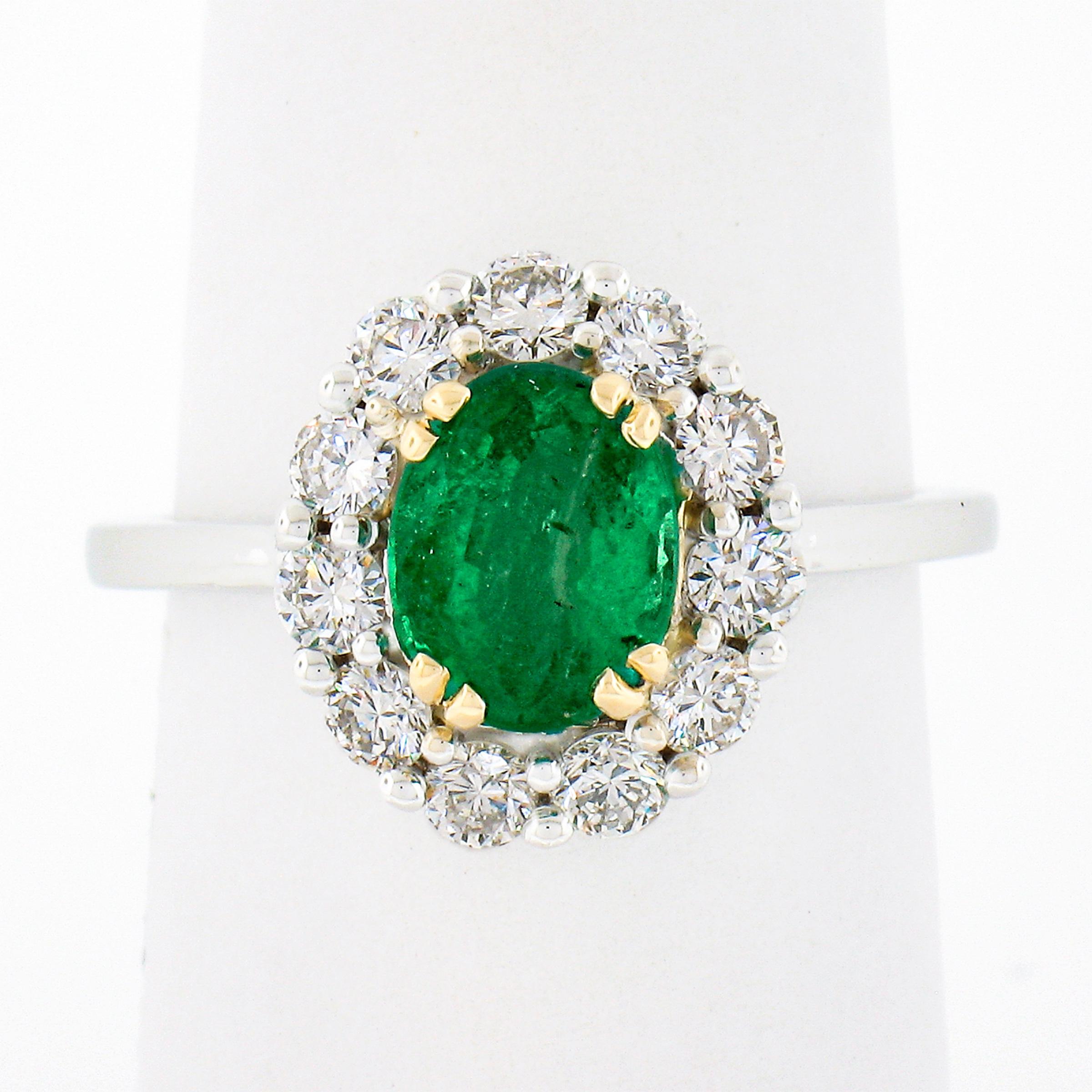 You are looking at a truly breathtaking, custom designed, emerald and diamond ring that is newly crafted in solid 18k white and yellow gold. The oval cut emerald is neatly prong at at the center and displays a truly gorgeous vivid green color that's