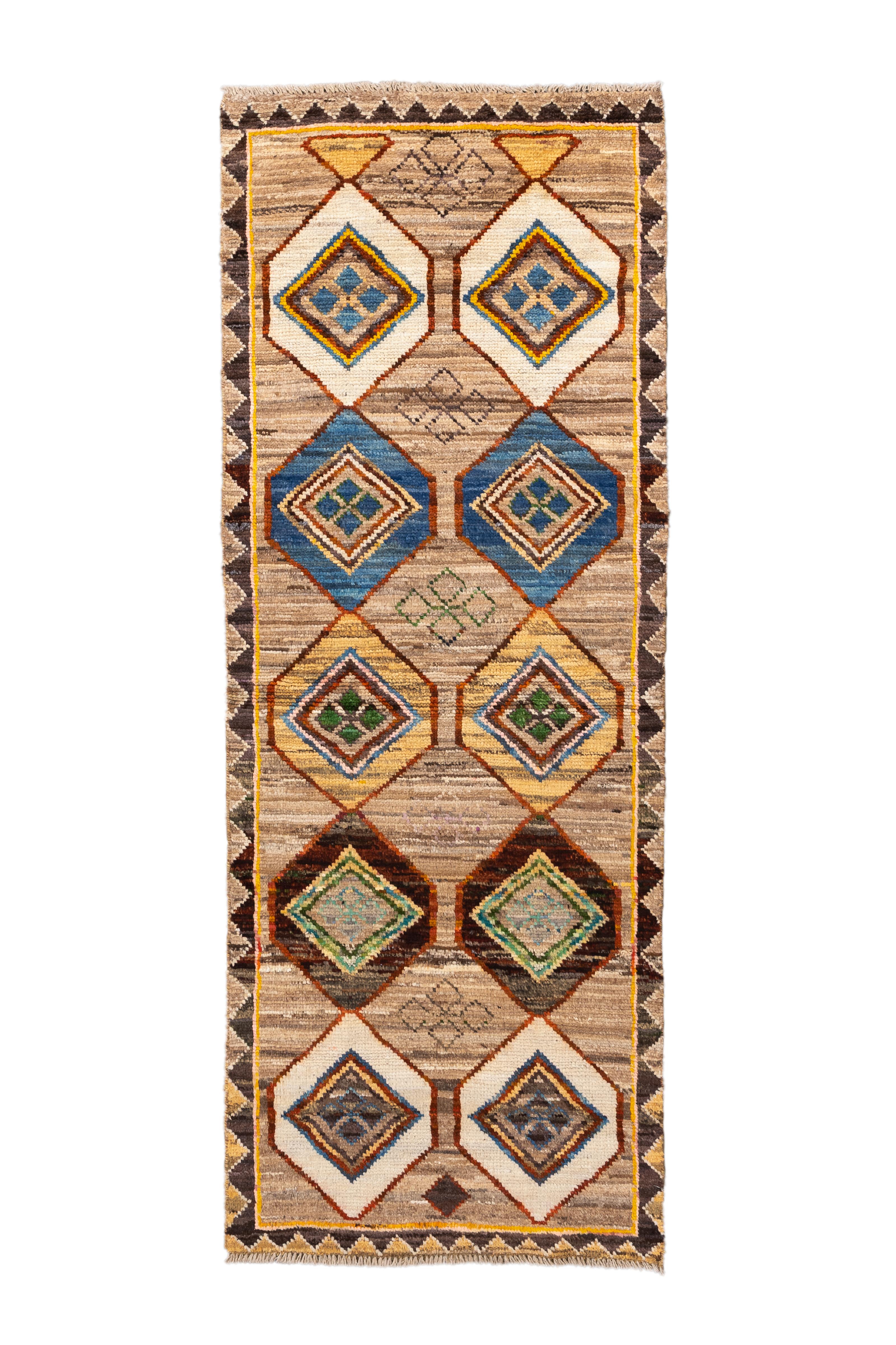  Questo nuovo runner marocchino si fa notare per il suo motivo ritmico a rombi in una tavolozza di tonalità sature - indaco, smeraldo, senape, ruggine e avorio - tutte inserite in un caldo campo marrone variegato. Il design è caratterizzato da