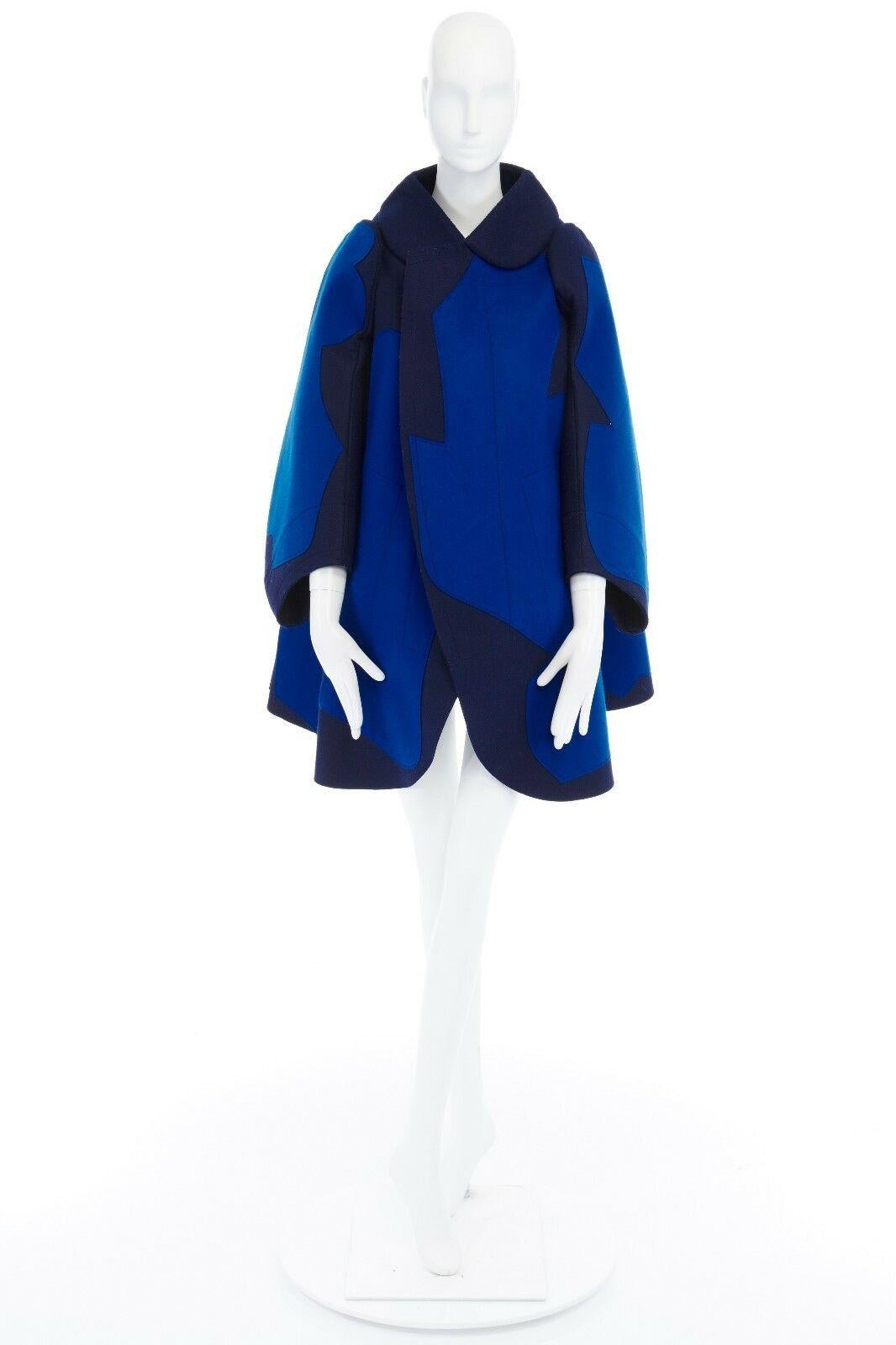 COMME DES GARCONS 
FROM THE FALL WINTER 2012 COLLECTION
Nylon, cotton, wool • Navy base with cobalt blue abstract shape stitched overlay • Flat packed design • Stiff structured wool-felt • Rounded collar • Voluminous curve-cut sleeves • Protruding