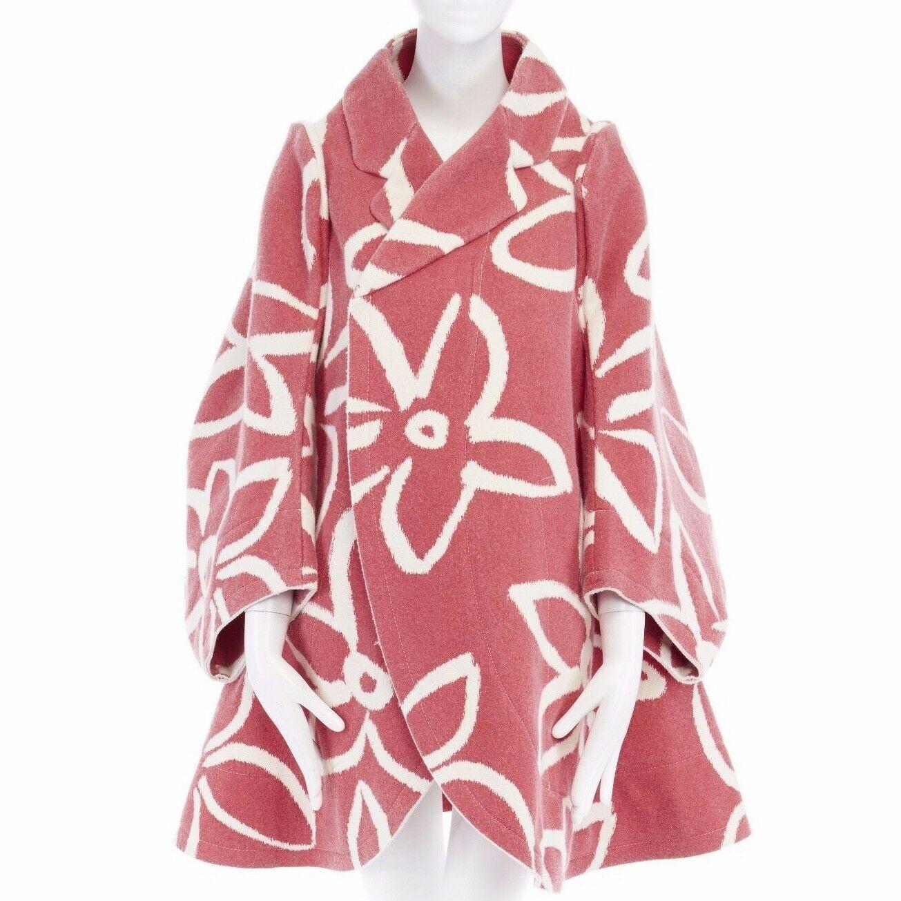 COMME DES GARCONS 
FROM THE FALL WINTER 2012 COLLECTION
Nylon, cotton, wool • Pink base with white floral print • Flat packed design • Stiff structured wool-felt • Rounded notched collar • Curved-cut sleeves • Protruding shoulders • White stitching
