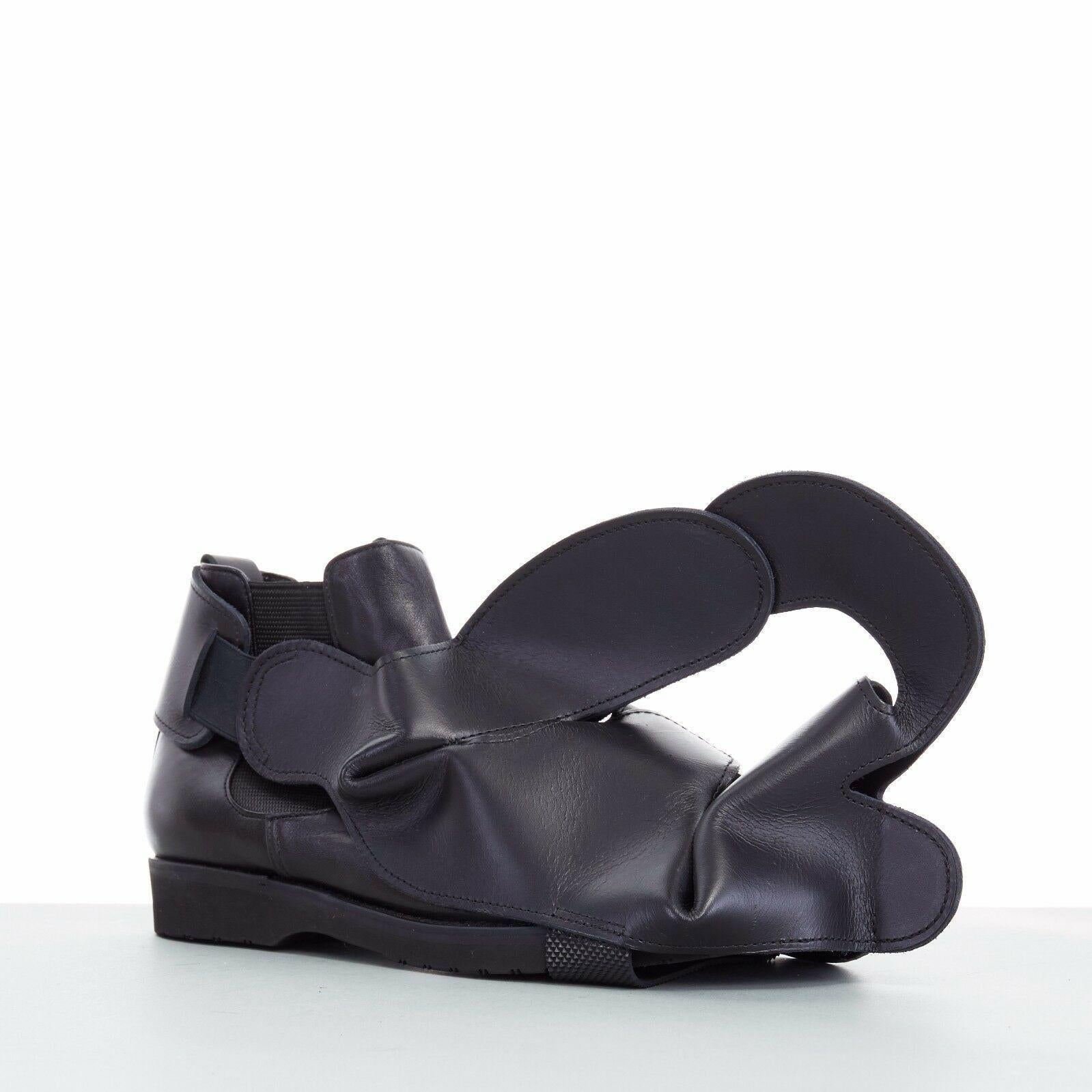 new COMME DES GARCONS SS14 rare black structured padded leather shoe cover
COMME DES GARCONS
FROM THE SPRING SUMMER 2014 COLLECTION
SUPER RARE AND HIGHLY COLLECTIBLE
Black leather upper . 
Abstract structural constructed upper . 
Elasticated sling