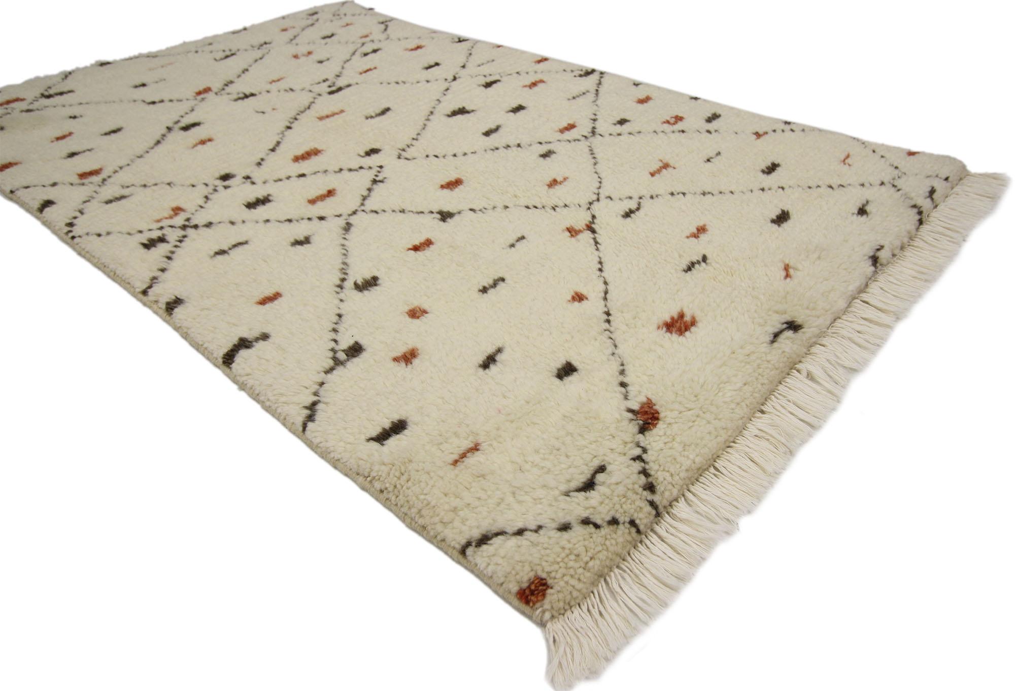 30310, new contemporary Moroccan Berber style accent rug. This hand knotted wool Moroccan style accent rug features a tribal style. The shaggy off-white colored wool pile is patterned with an irregular diamond lattice and dotted with rectangular