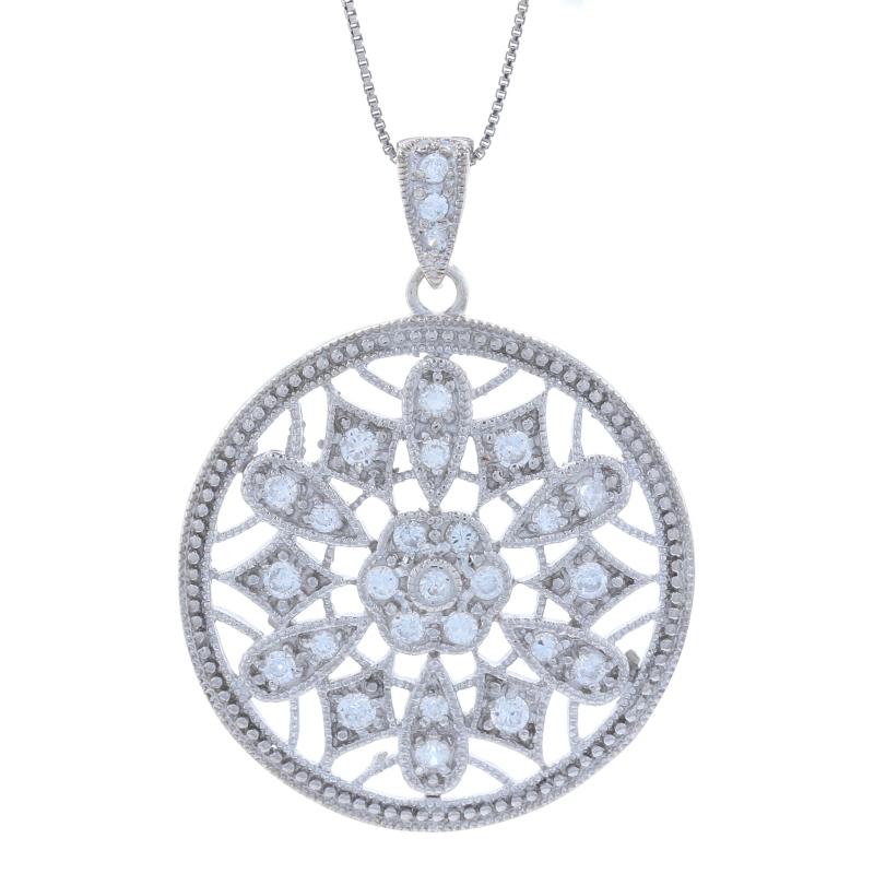 This beautiful new set features a flower accented circle pendant hanging from a box chain necklace. The pendant is encrusted with sparkling white cubic zirconias bead set in an ornate design. The bail is also accented by CZs. The necklace secures