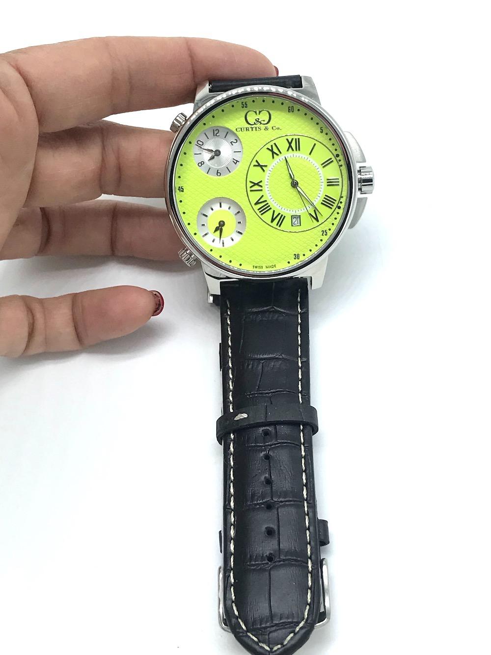 Curtis and Co Watch, 57 mm Big Time Air, 3 Time Zone 
Swiss made. New condition, never worn, 30 mm green colored dial with 3 time zones. Black strap. 57 mm includes outside buttons. Set watch to 3 different time zones includes date calendar. Quartz,