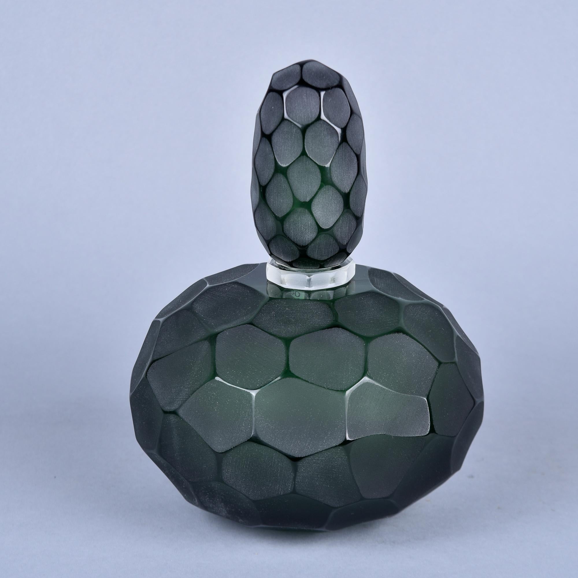 New and made in Italy by an unknown Murano glass maker, this perfume bottle is 11” tall with the stopper on and 8.5” diameter. Heavy, dark bottle green glass has cut and polished surface detail - called battuto in Italian - which provides an