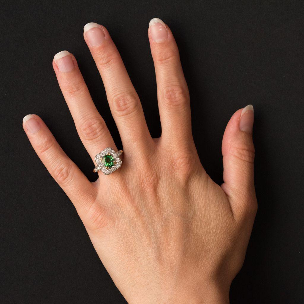 Ring in Platinium and 18 carat yellow gold, eagle and dog heads hallmarks. 

Set with a central demantoid green garnet in a square shaped design set with 15 brilliant cut diamonds. On each side the beginning of the ring band is set with 2