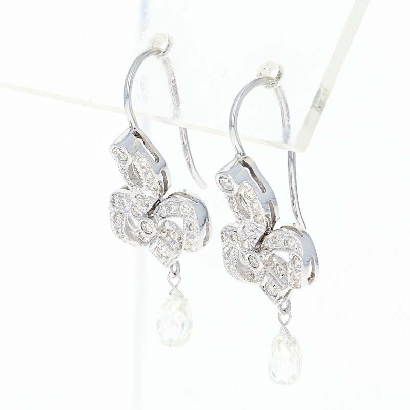 Make this exquisite set of earrings the highlight of a special birthday or milestone anniversary! Fashioned in high purity 18k white gold, the earrings feature a trefoil design outlined in diamond accents and milgrain borders. Dangling briolette