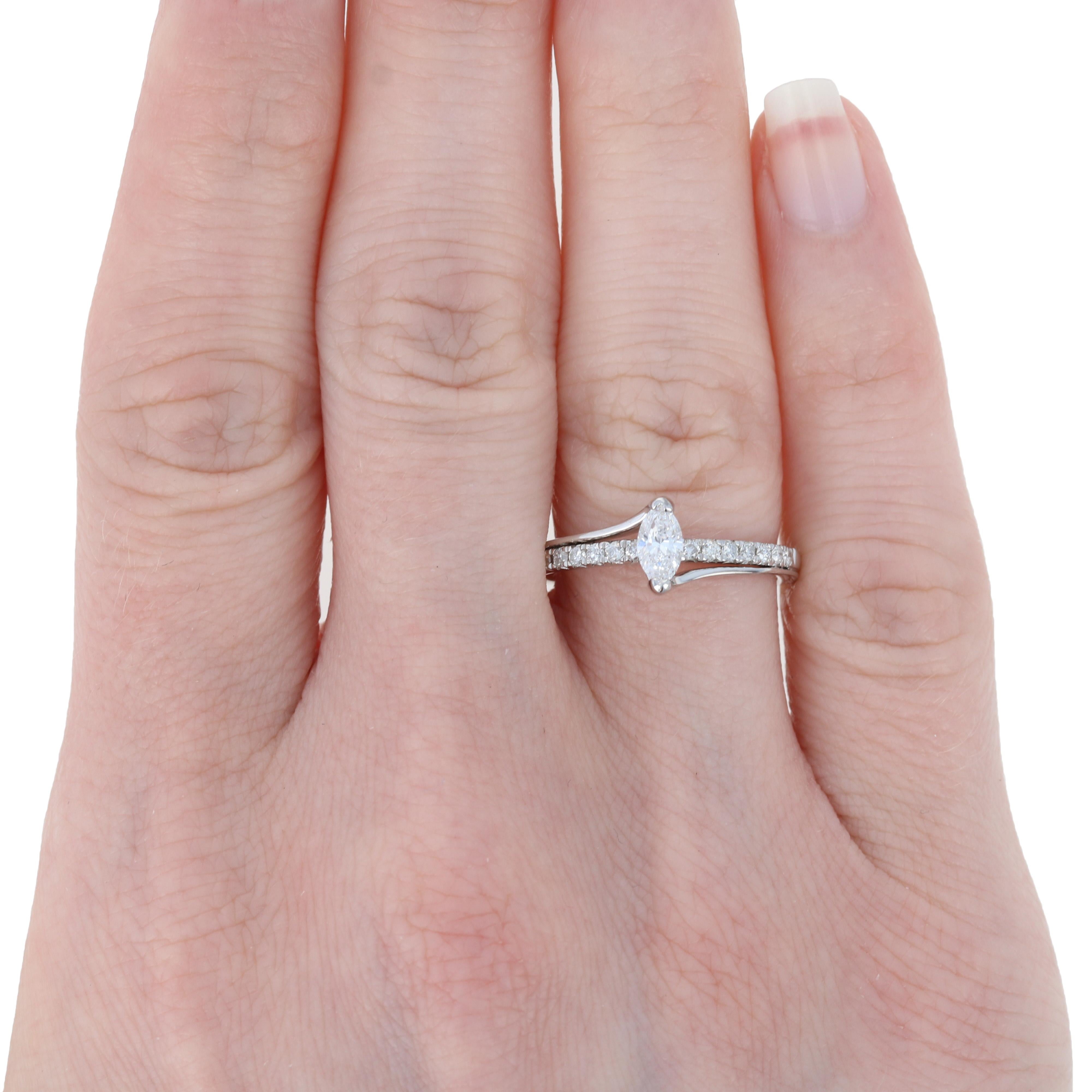 Verblüffen Sie Ihre zukünftige Braut, wenn Sie ihr einen Antrag mit diesem atemberaubenden Diamant-Verlobungsring machen! Dieser NEUE Ring aus 14 Karat Weißgold im raffinierten Bypass-Stil präsentiert einen Solitär mit einem Gesamtgewicht von 0,31