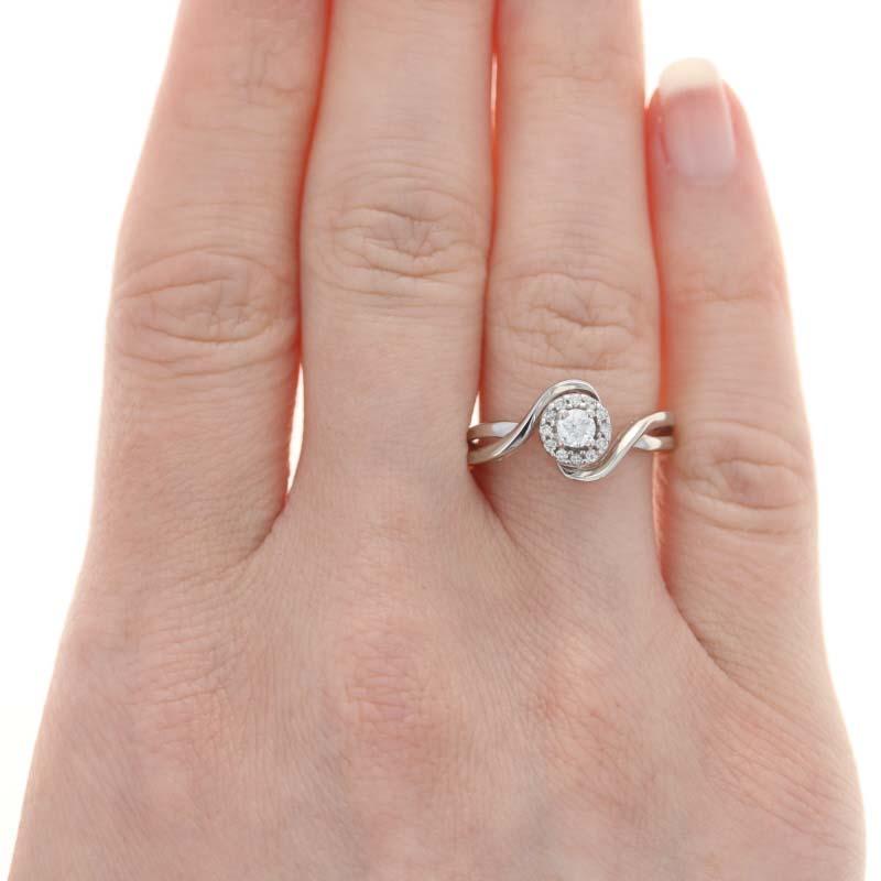 Today's style-conscious bride will adore this wedding set! Fashioned in timeless 10k white gold, this NEW set is comprised of an engagement ring and matching wedding band. The engagement ring features a bypass-style band adorned in the enter with a