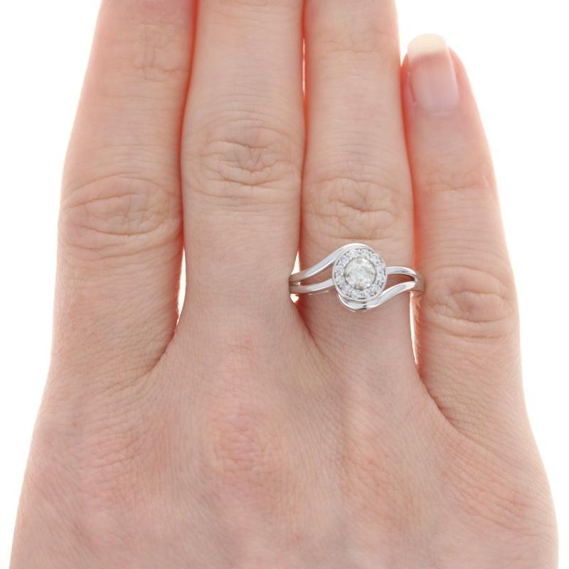 Shower the love of your life with radiant diamonds! Composed of glistening 14k white gold, this NEW wedding set consists of an engagement ring and a wedding band. Fashioned in a glorious bypass style, the engagement ring showcases a .20 carat total