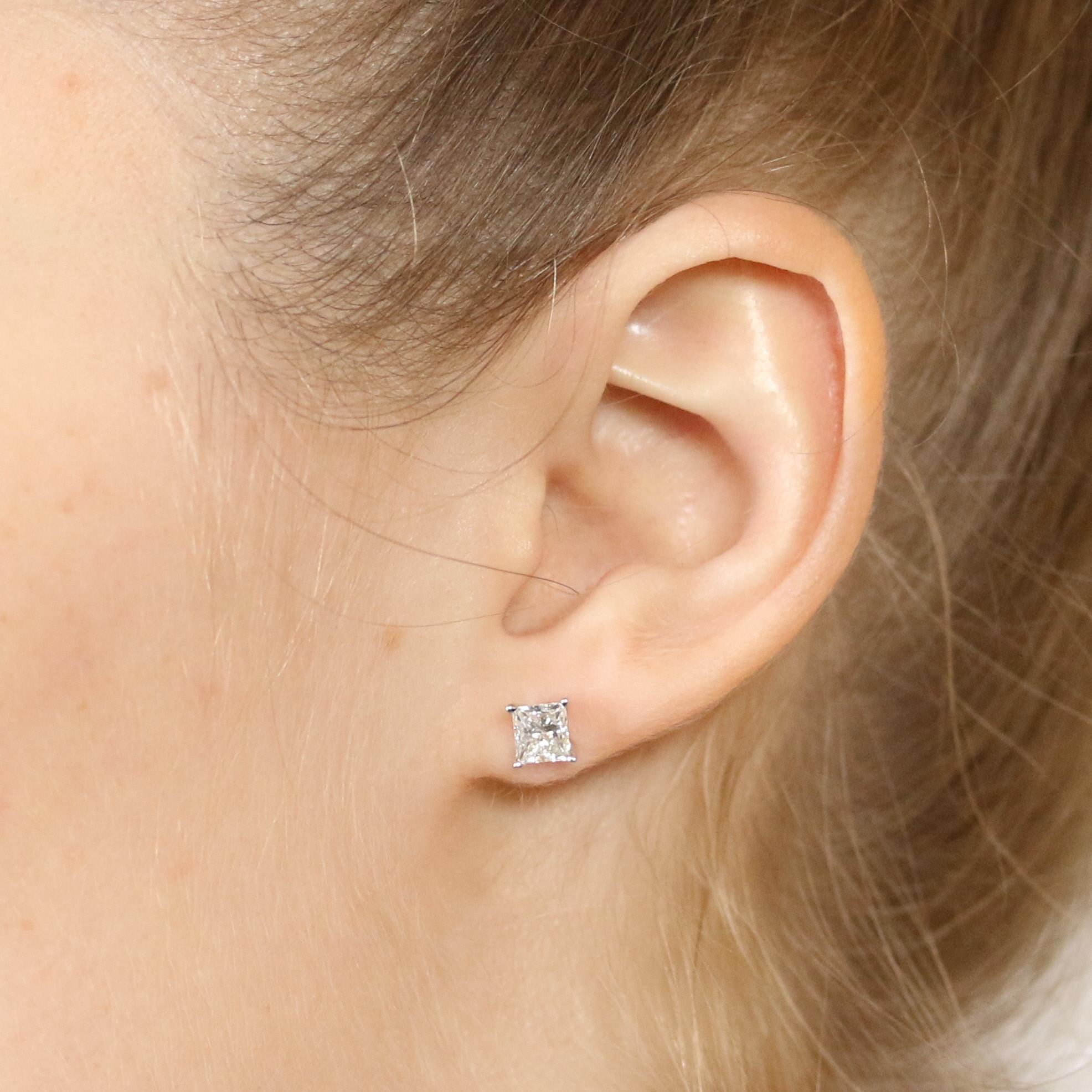 Endless style possibilities await you with this resplendent pair of earrings! Crafted in high purity 18k white gold, these NEW studs showcase princess cut diamonds held in classic four-prong basket mounts which allow light to cascade through the