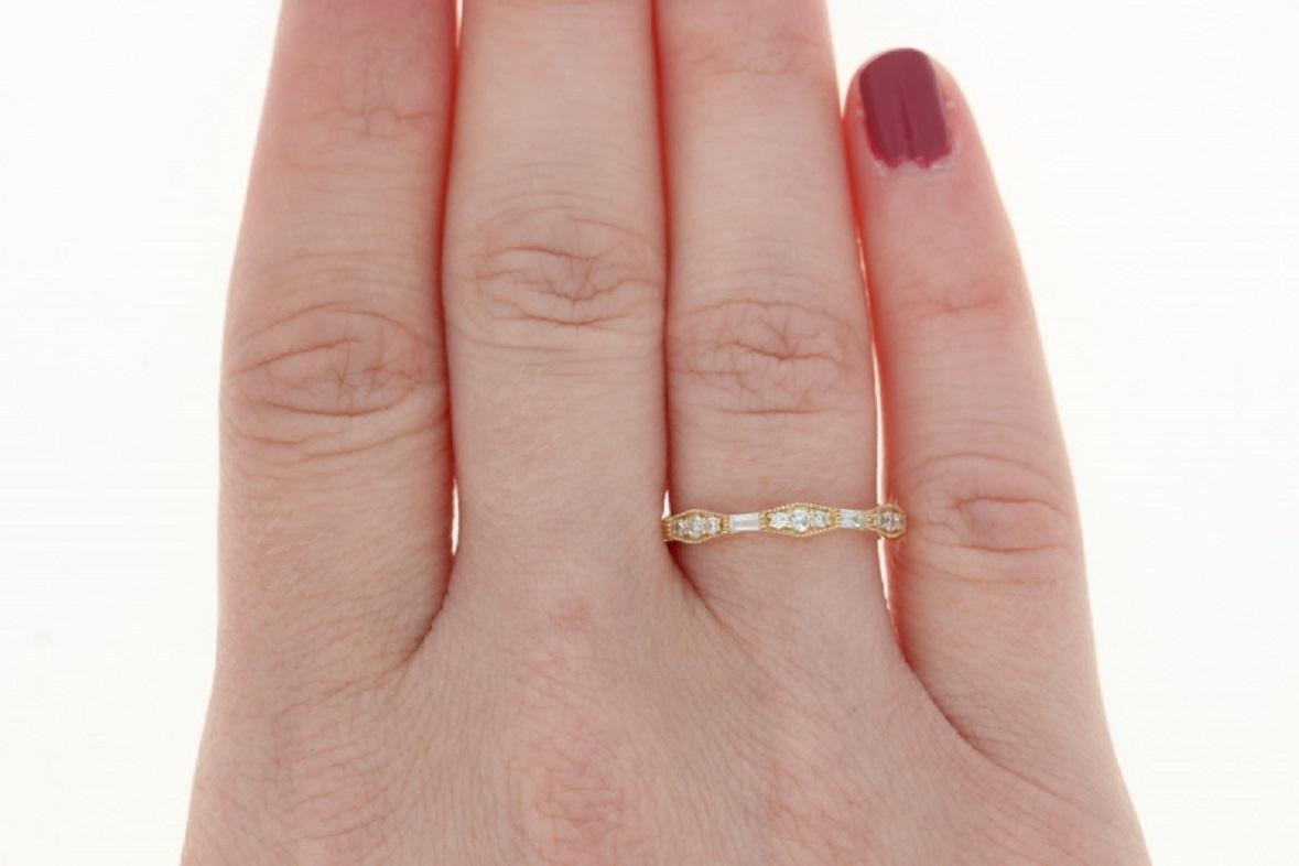 Celebrate and symbolize your marriage with this elegant NEW wedding band! Fashioned in a vintage-inspired geometric design, this 14k yellow gold ring showcases a glittering array of white diamonds set across the band's face and sweetly accompanied