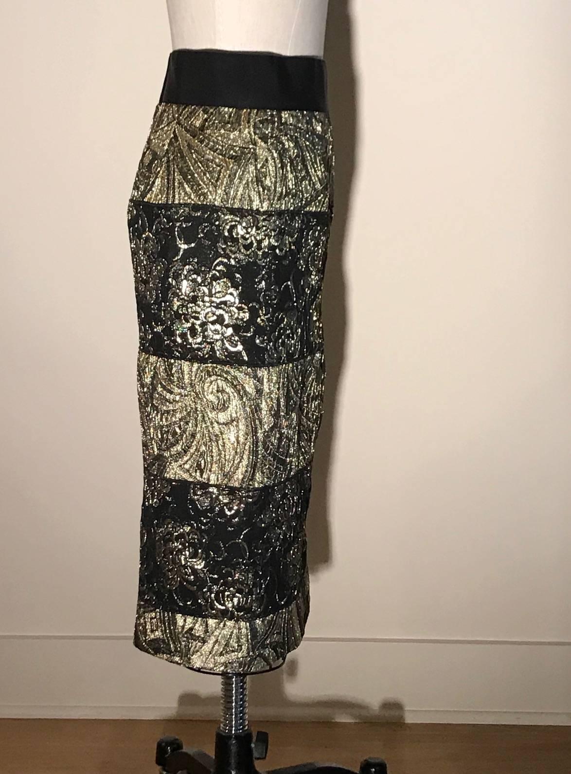 Dolce & Gabbana metallic gold and black jacquard skirt with alternating panels of floral and geometric patterns. Grosgrain waistband. Back slit at center. Closes at back with a zip and two snaps.  

74% polyester, 19% nylon, 7% acrylic. 
Fully lined