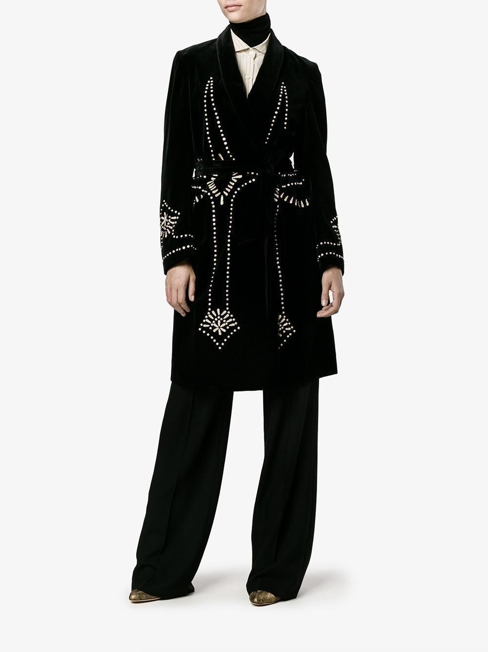This knee-length coat has been designed from black velvet and was inspired by the fabled Luisa Casati — also Italian. 
Featuring a shawl collar
Long sleeves
Adjustable self-tie waist belt
Silver-tone sequin embellishment
Outer Composition:
