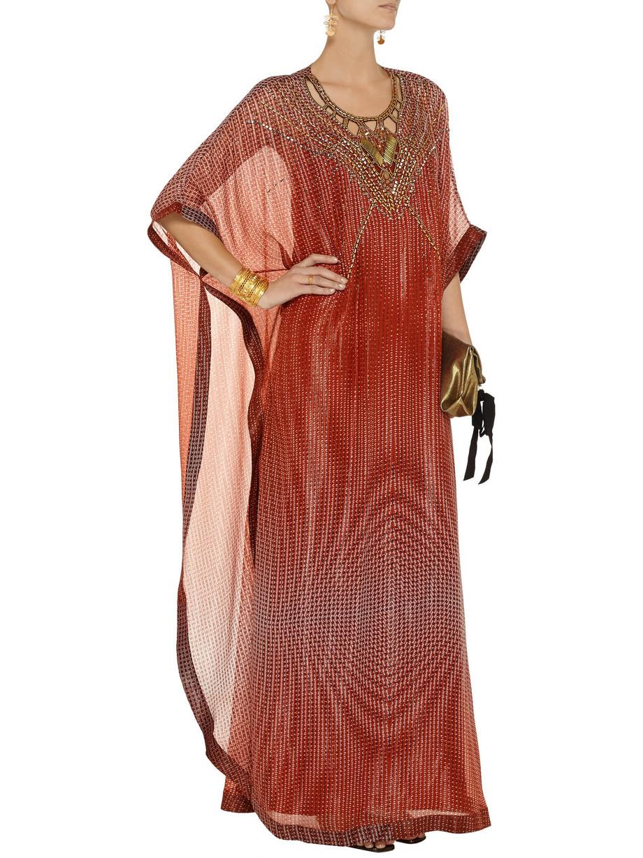 This wonderful copper-colored kaftan by Diane von Furstenberg is a glamorous take on a holiday staple. It's cut from sheer silk-crepe and heavily embellished with gold-tone metal beads. The lantern dot russet-print and cut-out detailing lend the