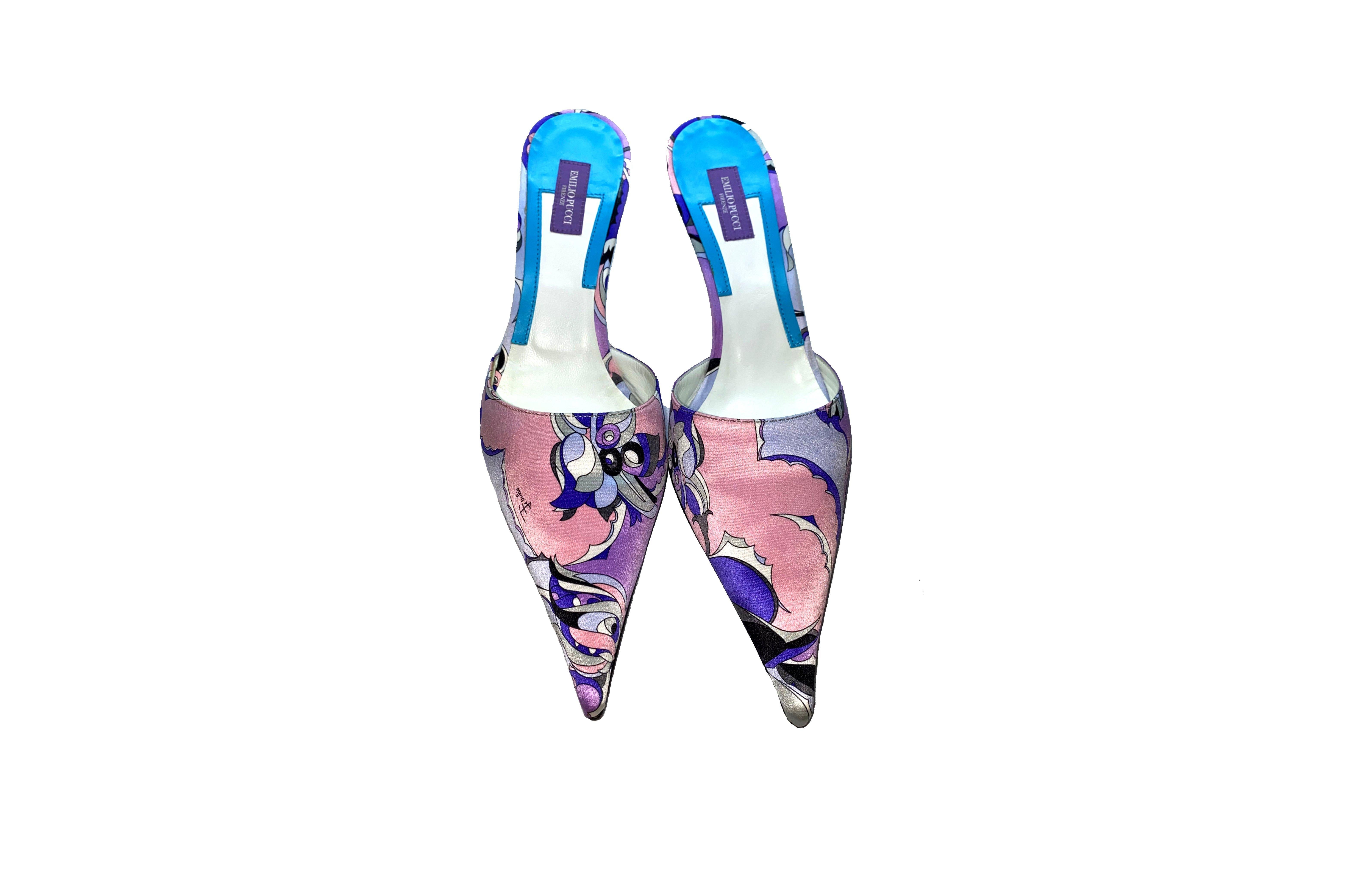 Diese auffälligen Pantoletten sind ein Beispiel für die energiegeladene Energie von Pucci. Sie sind aus glänzendem Stoff gefertigt und mit dem Emilio Pucci Signature-Print versehen:: der an das Erbe der Marke erinnert. 

Dieser Pucci-Absatz ist