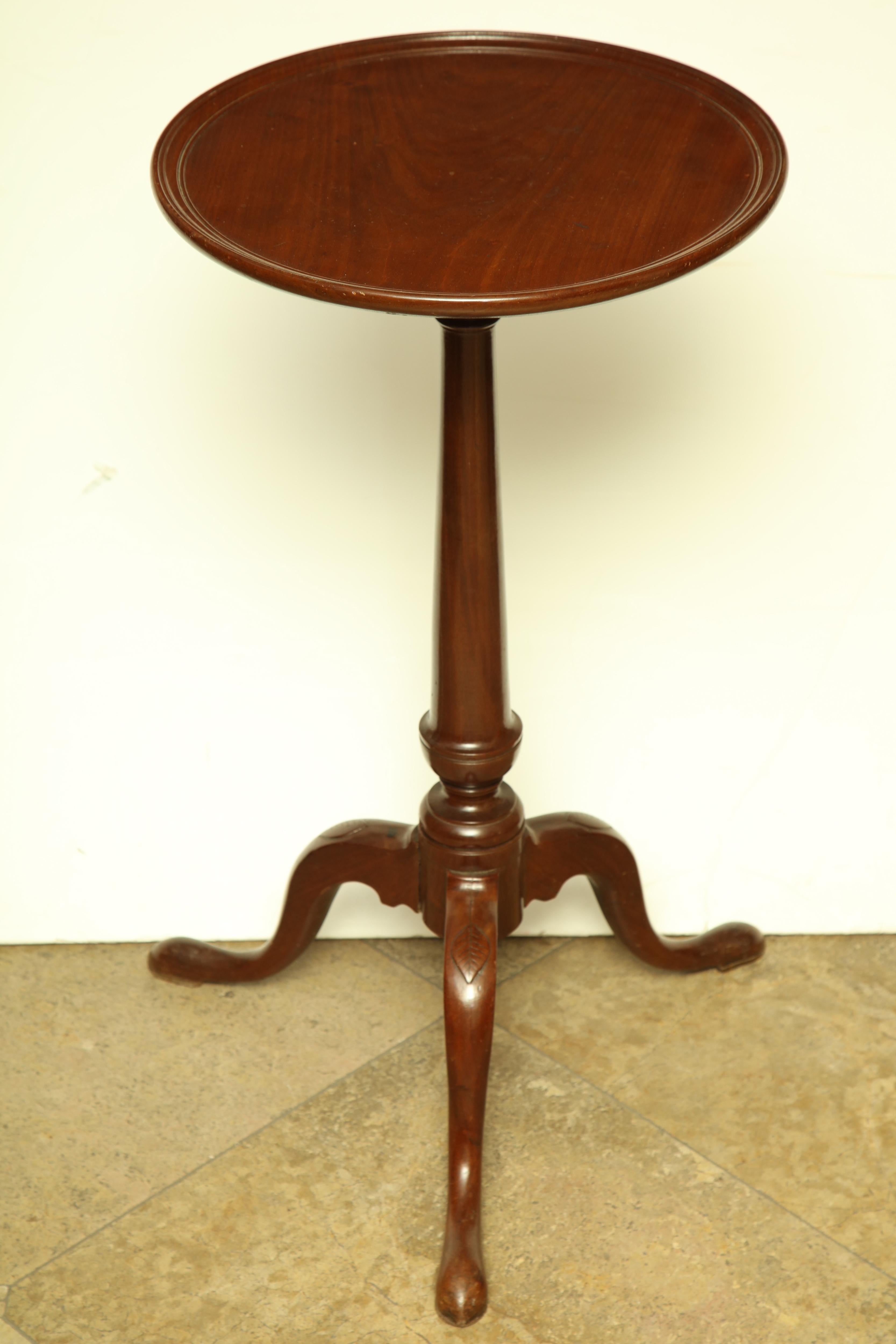 An unusual New England mahogany dish top candlestand with tapered urn shaft, cabriole legs and fine carved leaf knee.