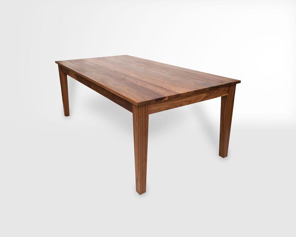 Our modern take on a classic shaker farm table. The New England Farm Table's features slim rails, neat but bold reveals, and a chunky tapered leg. When paired with sustainably harvested walnut, the crisp contrasts yields a classic design with a