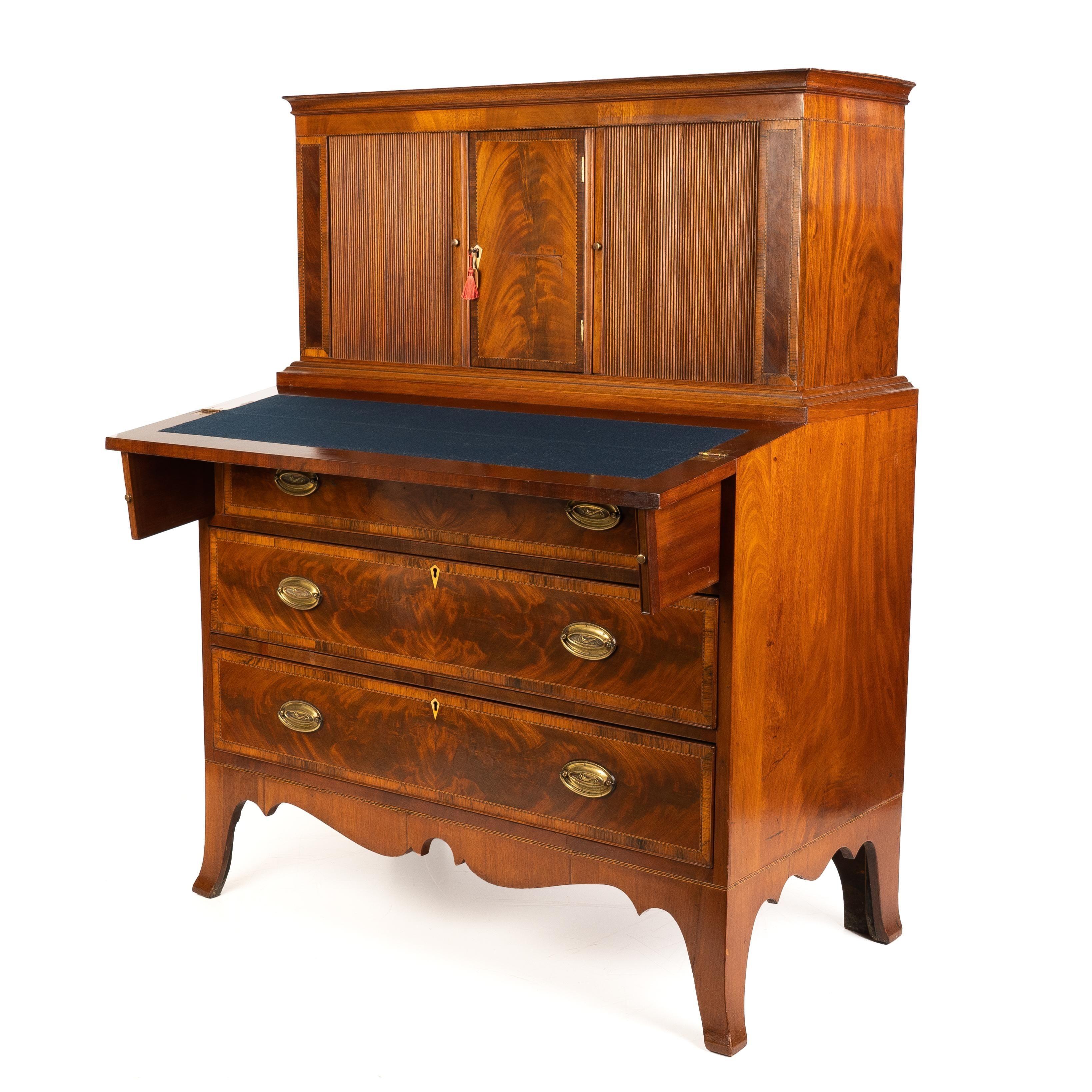 American Hepplewhite tambour secretary flip top desk. Composed of mahogany solids and figured mahogany veneers along with contrasting patterned string inlays and rosewood cross banding. The case has three graduated cock beaded drawers fitted with