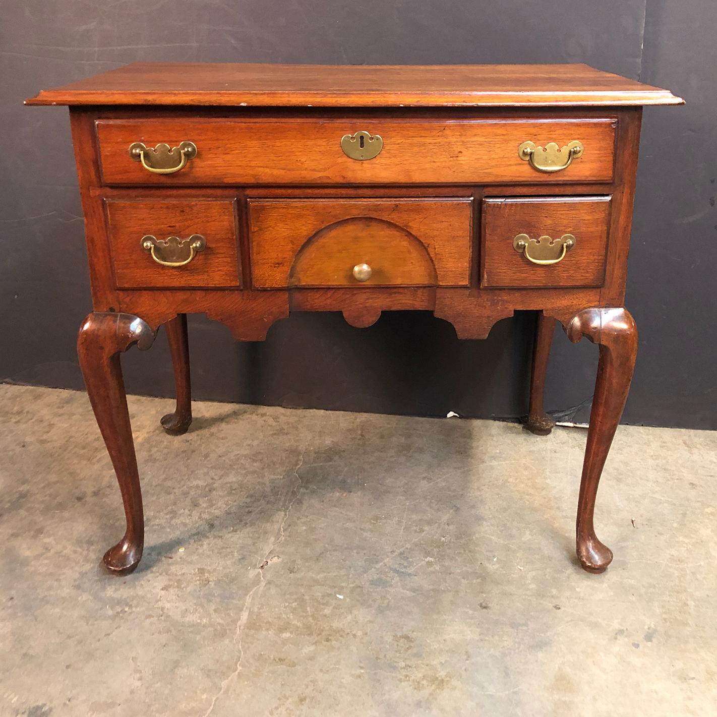 A fine 18th century Queen Anne New England walnut four-drawer low boy dressing table with brass handles, cabriole legs and pad feet.