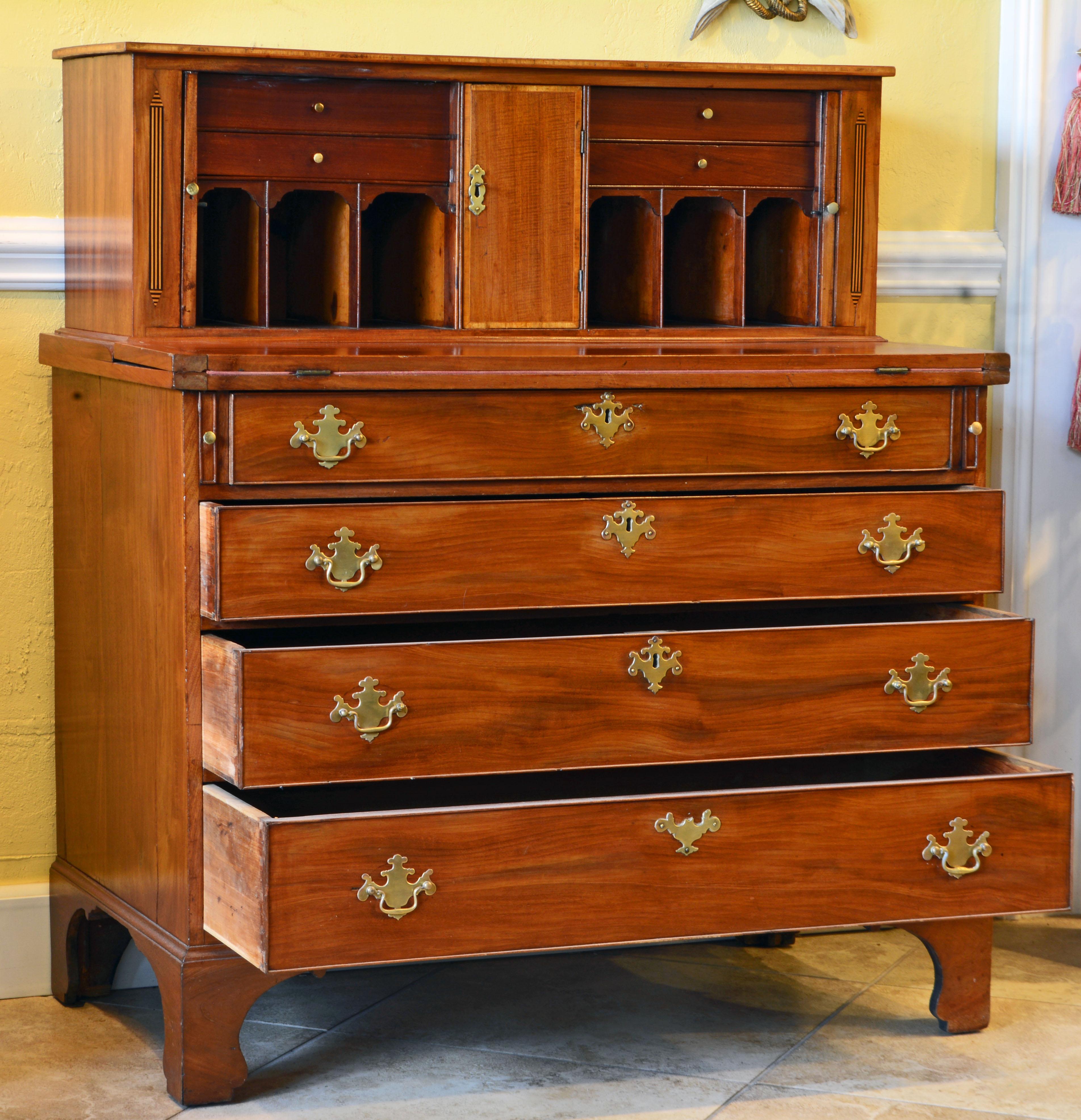 This fine federal mahogany secretary desk features an upper section with tambour doors opening up to interiors fitted with pigeon holes and small drawers centering a banded tiger maple door which opens up to a compartment fitted with pigeon hole and