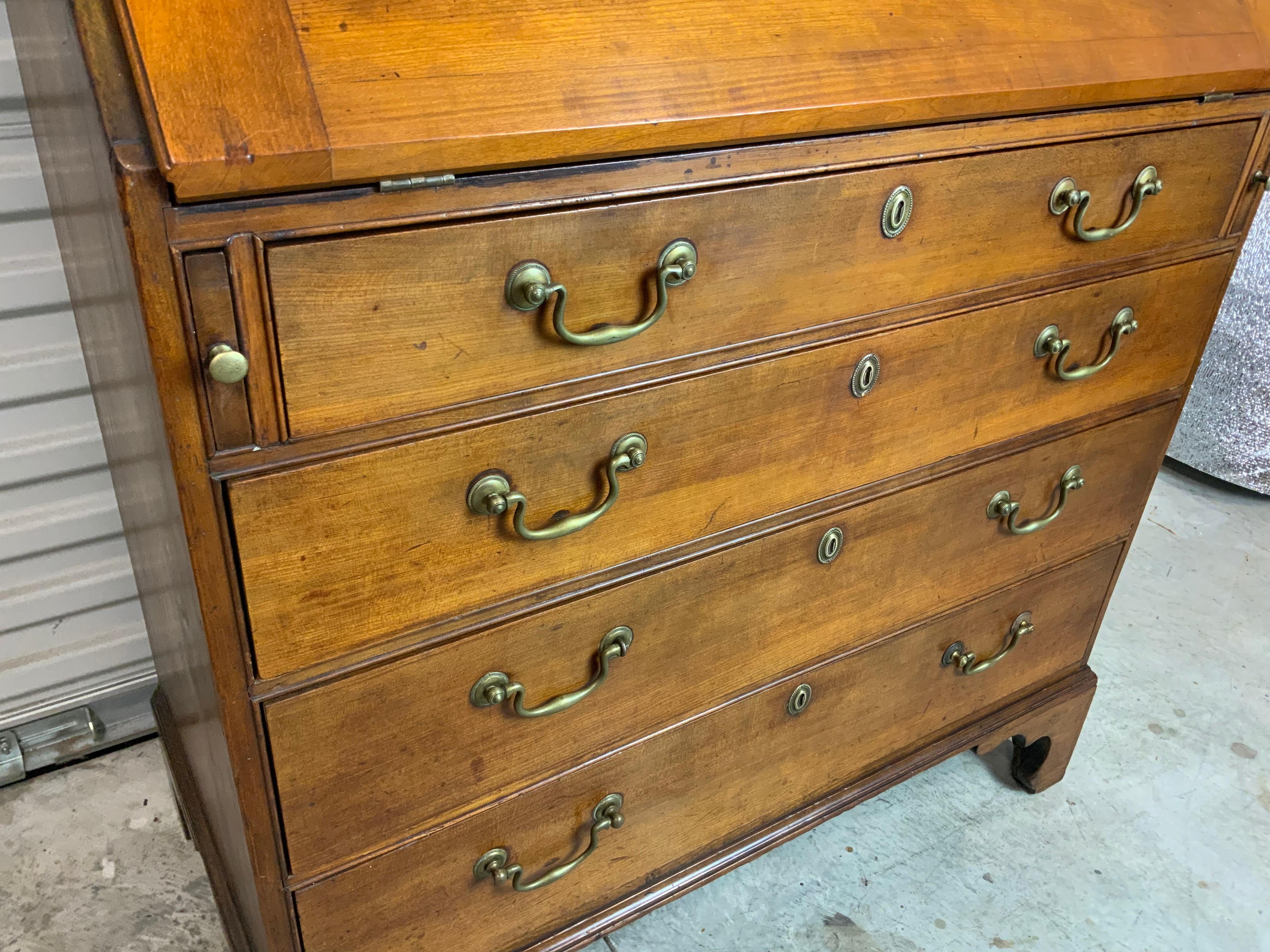 New England late 18th / early 19th century Cherry slant front desk sitting on nicely formed tall bracket feet. The hardware appears to be original and all the drawers are working properly. Original working lock and key for the lid and nicely