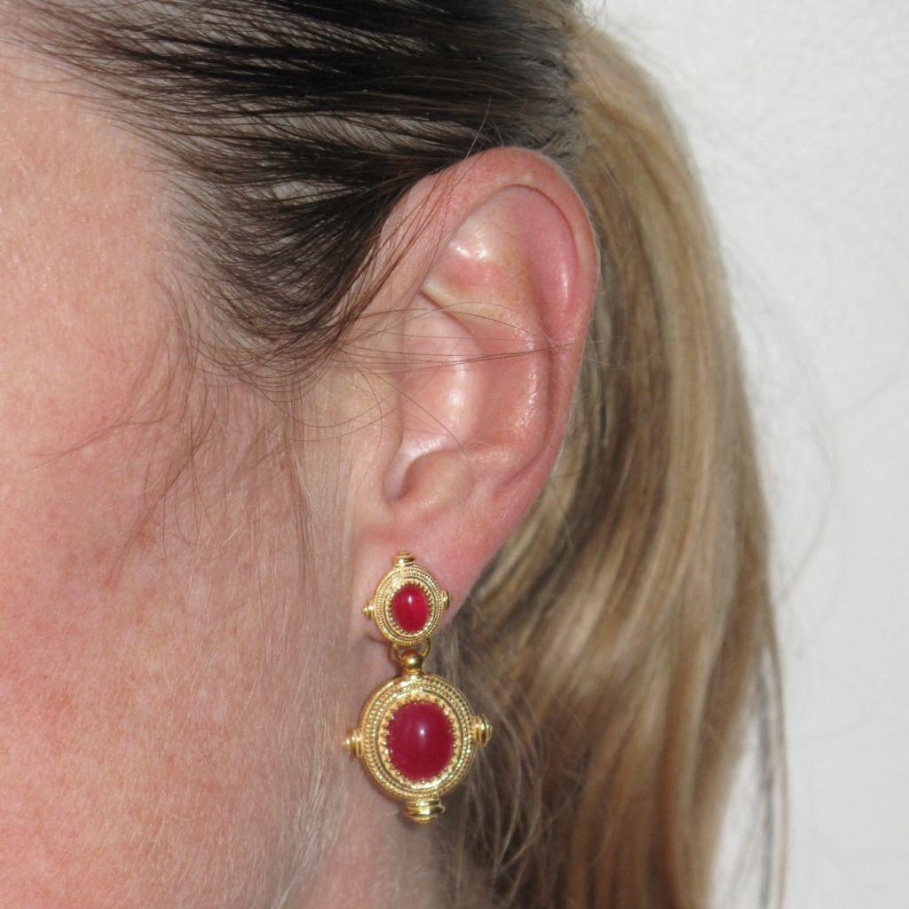 For pierced ears.
Pair of earrings in silver and yellow gold.
Two ovals, one below the other, are set with a pink cabochon stone surrounded by a beaded motif and bordered with a braid. The hanging system is butterfly.
Length: 3.5 cm, width: 2