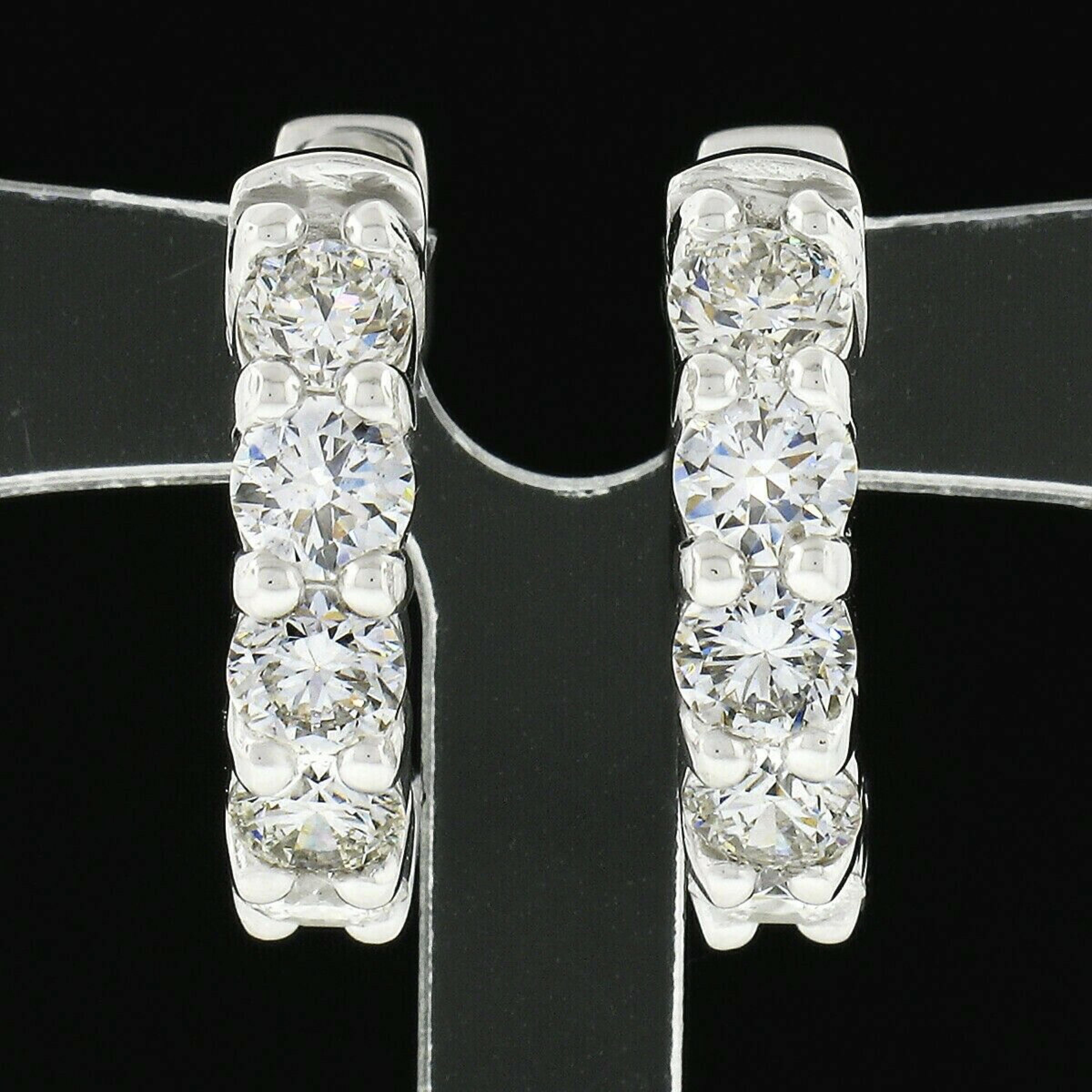 This elegant pair of hoop earrings was newly crafted in solid 14k white gold and features exactly 1.58 carats of super fine quality round brilliant cut diamonds. These fiery diamonds are neatly shared-prong set across the front side in sets of 5,