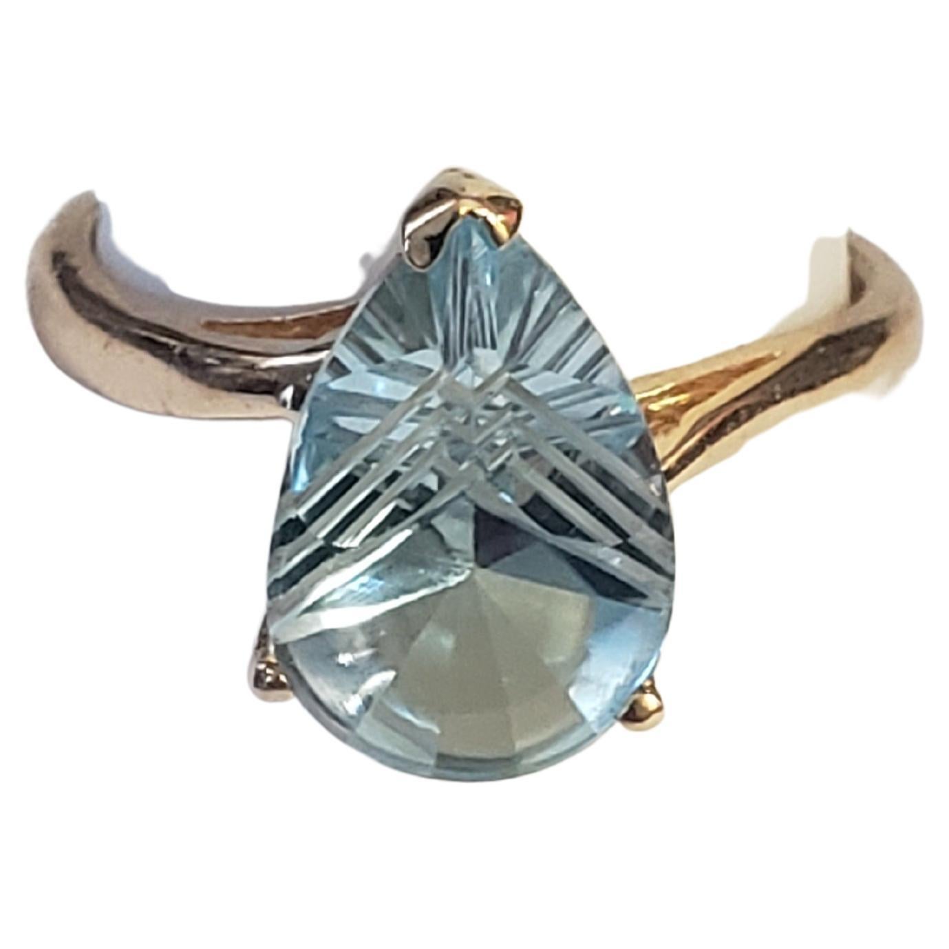 Cette magnifique bague de Nature est ornée d'une topaze bleue naturelle de 3 carats de taille spéciale, sertie dans un anneau d'or jaune massif de 14 carats. L'étonnante pierre en forme de poire est rehaussée d'une délicate couronne, ce qui lui