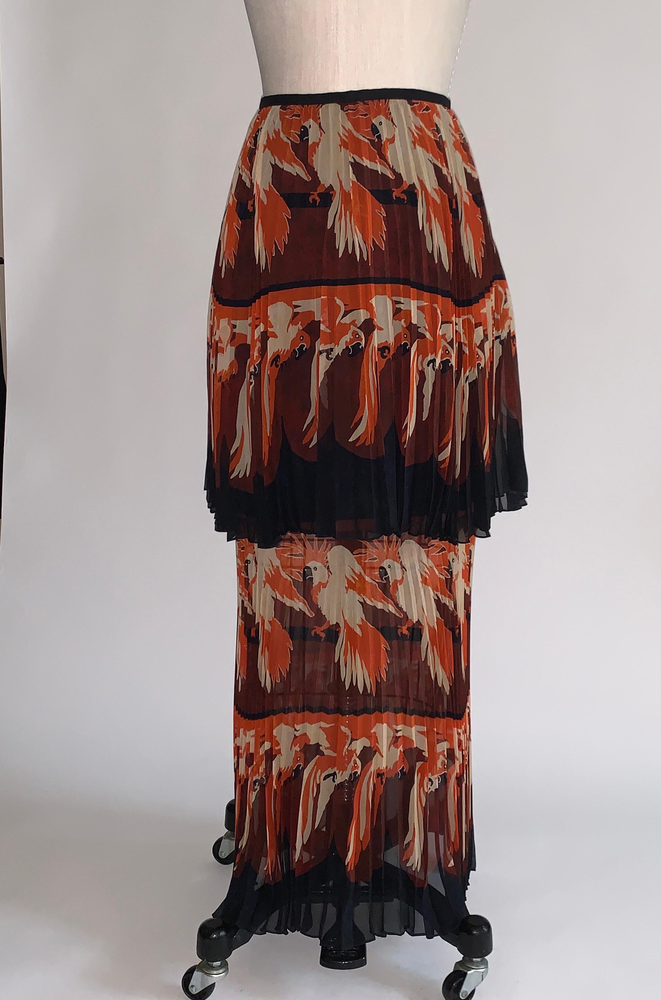 Fendi pleated layered long skirt with rows of orange and cream parakeets or parrots. One mid length layer floats atop a longer one. Side zip and hook. Lined to mid-length.

100% silk.

Made in Italy.

Size IT 40, approximate US 4.
Waist 27