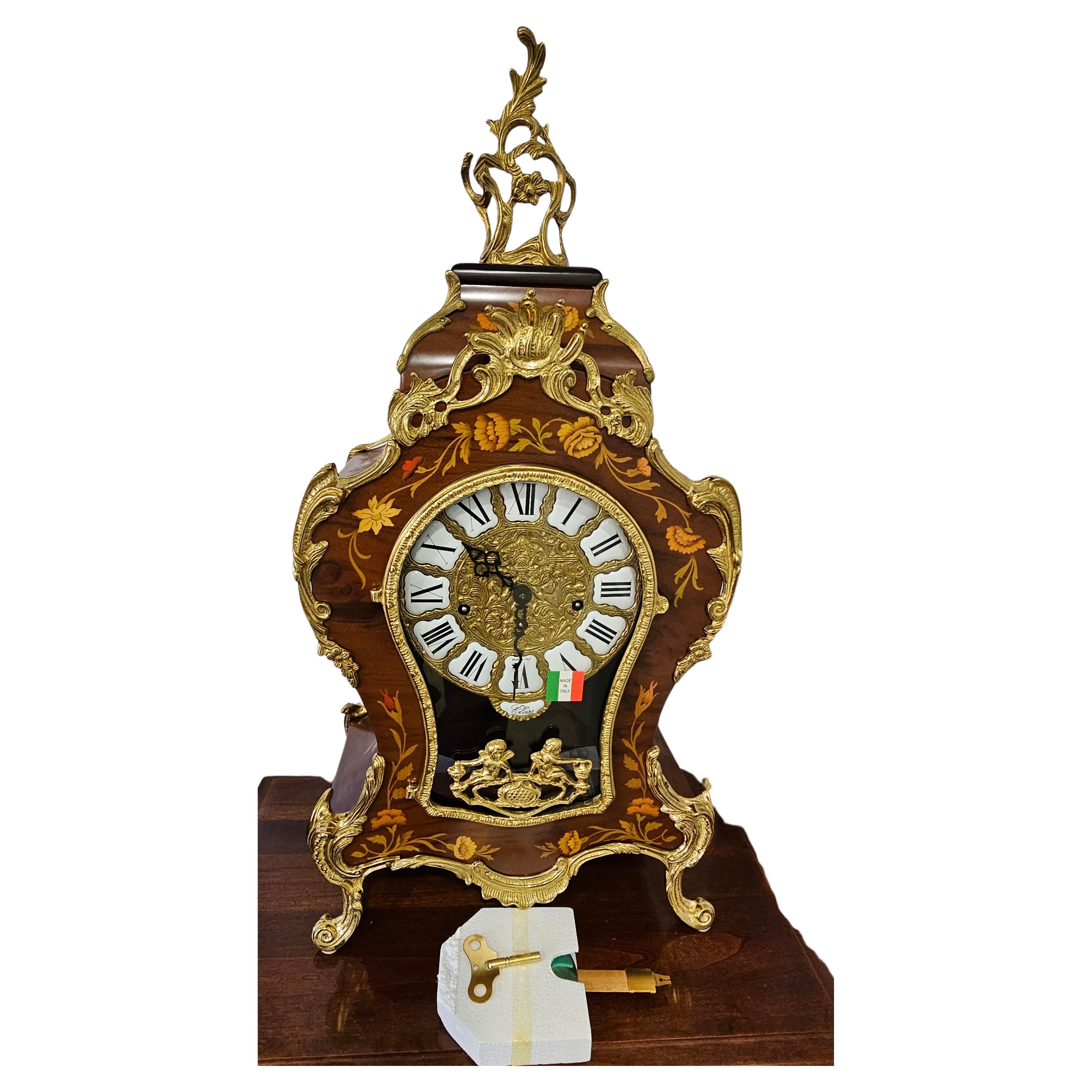 Horloge de cheminée allemande Franz Hermle du 21e siècle en marqueterie fine italienne DeART et boîtier en bronze doré, en état neuf, boîte ouverte.
Horloge fabriquée en Allemagne par l'historique et très célèbre horloger Franz Hermle dans le