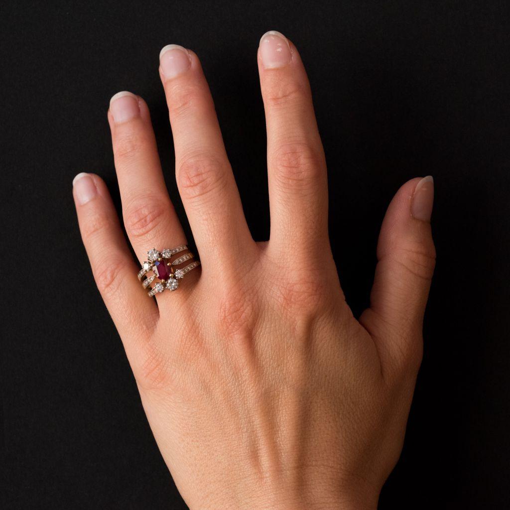 Ring in platinum and 18 karat yellow gold, eagle and dog heads hallmarks.   
This splendid ruby and diamond ring is claw set with an oval ruby accentuated above and below with 2 x 3 claw set brilliant cut diamonds. The three bands that compose this