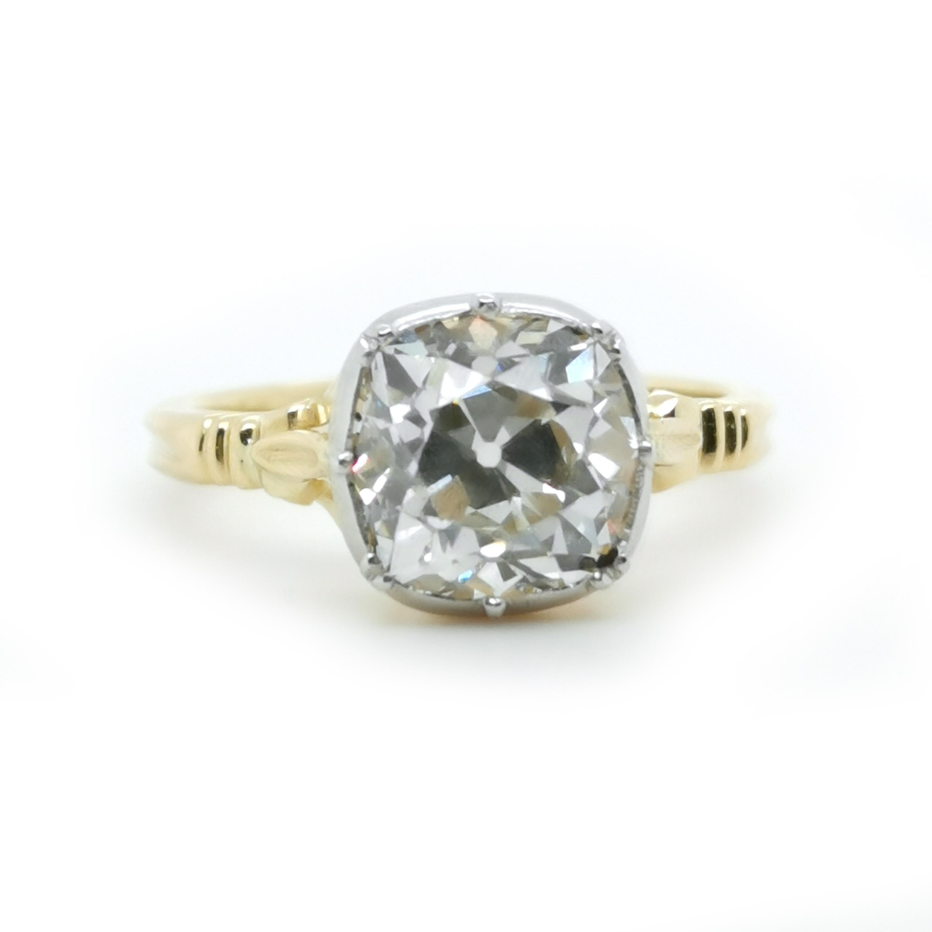 A new Georgian style diamond, gold and platinum solitaire ring, set with a 2.72 carat, J colour, VS2 clarity, cushion shaped old-cut diamond, in a platinum topped, cut down setting, onto a gold bowl, with fleur-de-lys trefoil shoulders, with two