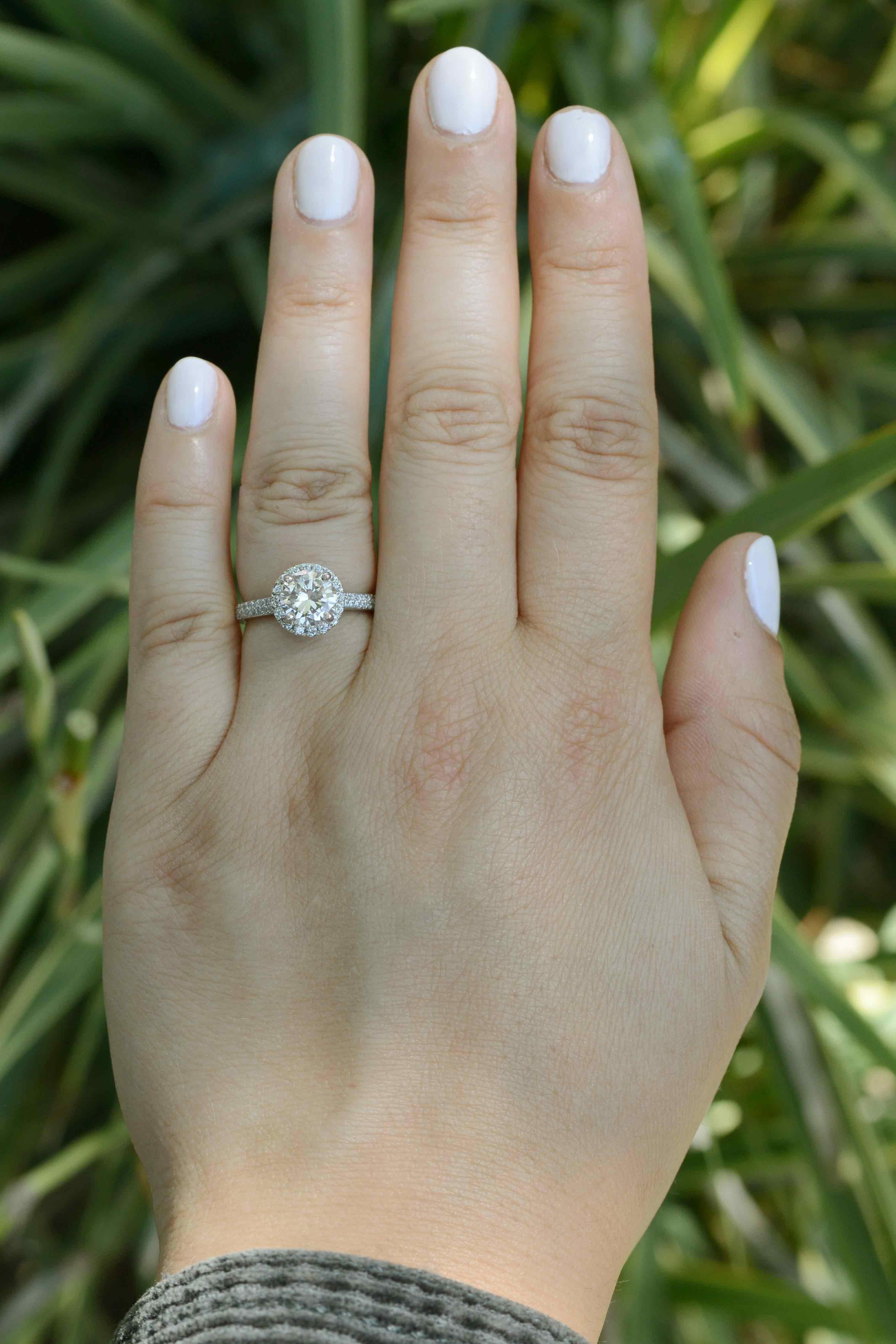 The Criscarre diamond halo solitaire engagement ring is a true classic. Centering on a 1.41 carat GIA certified round brilliant cut diamond, that captivates a dazzling, near colorless (J) sparkle and brilliance. Boasting nearly 2 carats total, the