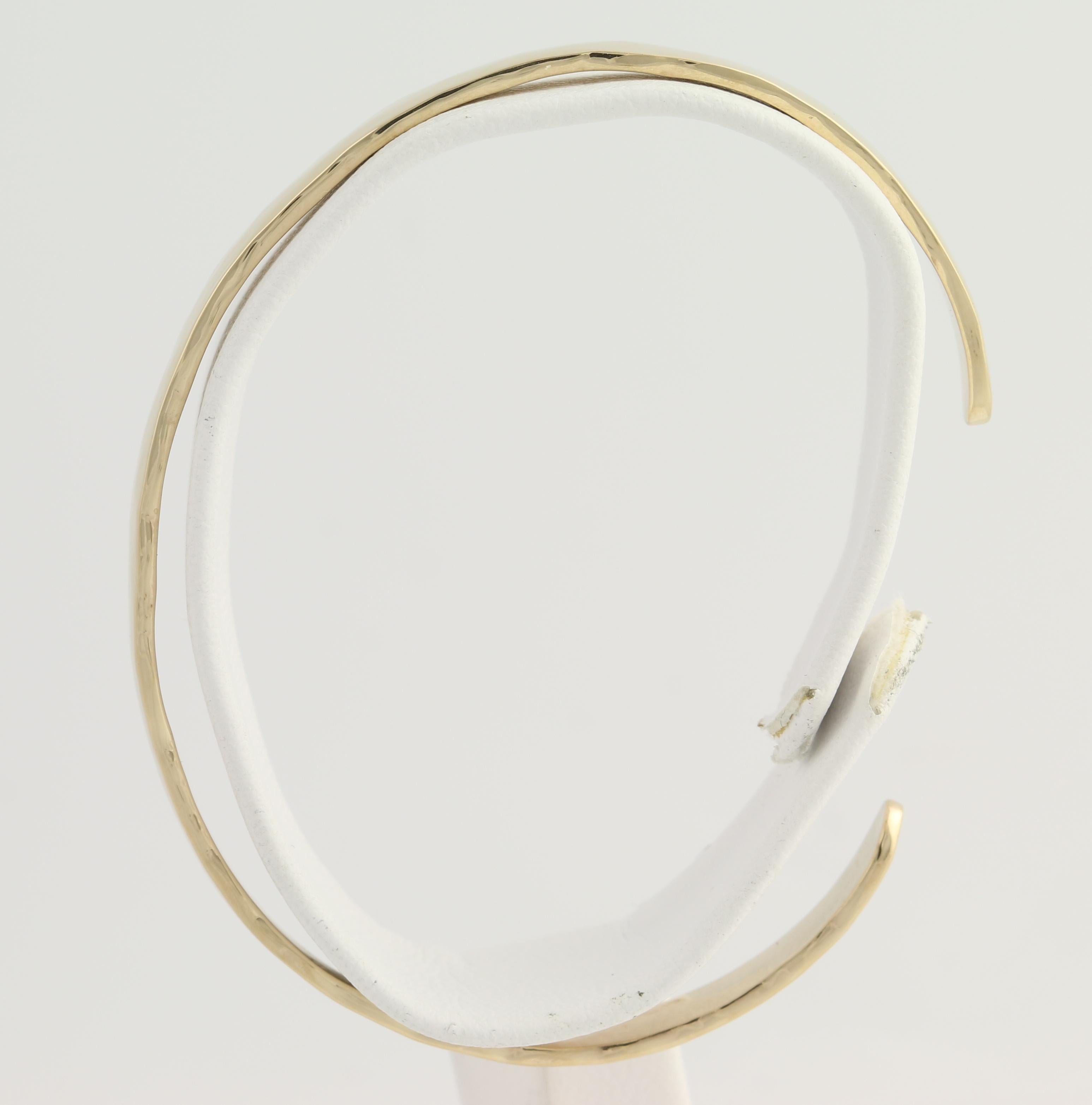 Treat yourself or a special friend to a chic, go-with-anything cuff bracelet! This brand-new piece is handmade from 14k yellow gold and the hammered surface is polished so that the cuff draws and reflects light with any movement. Solid in