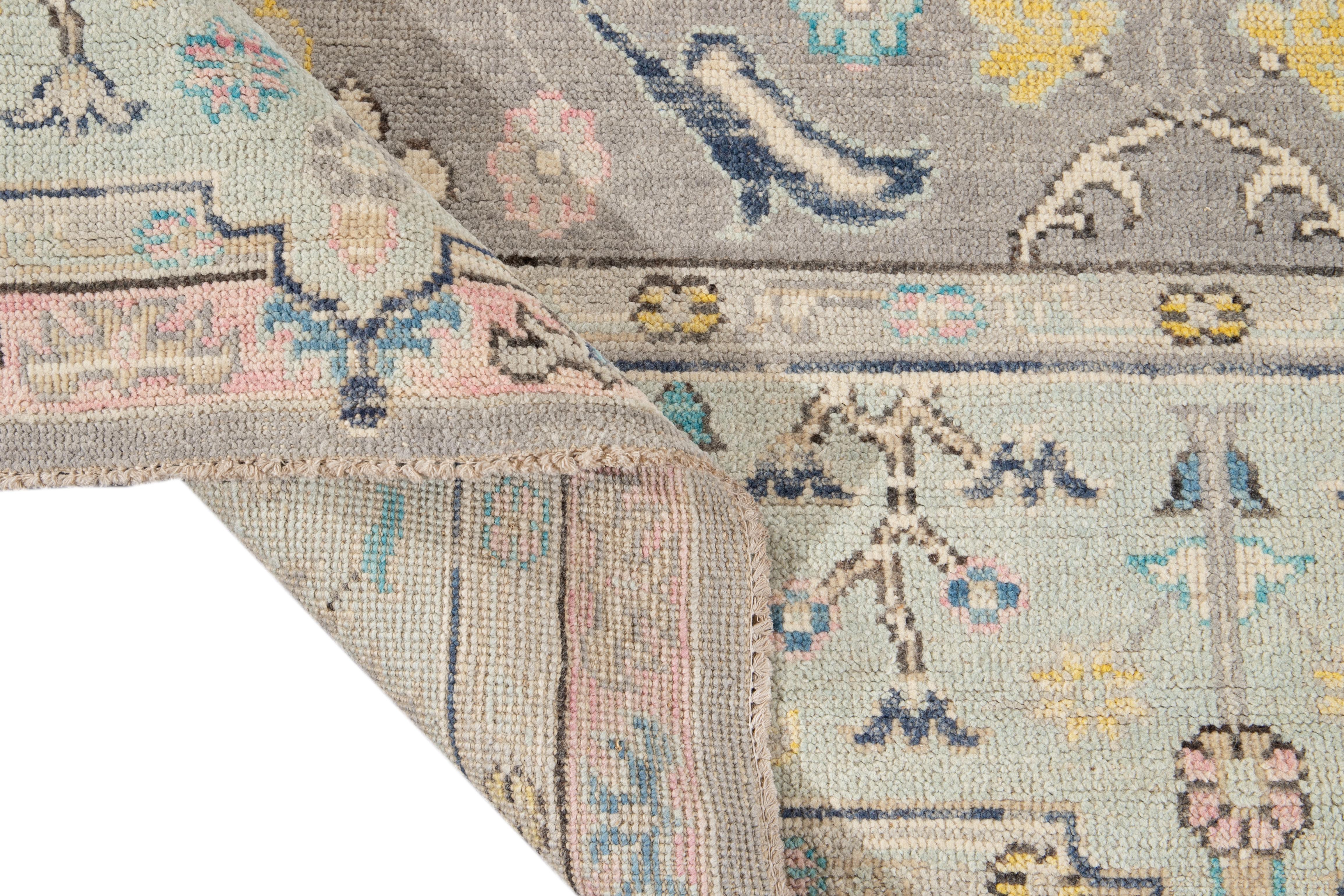 Beautiful contemporary Oushak hand knotted wool rug with a gray field. This rug has a frame of blue, pink, and multi-color accents in all-over floral design,

This rug measures: 9'2