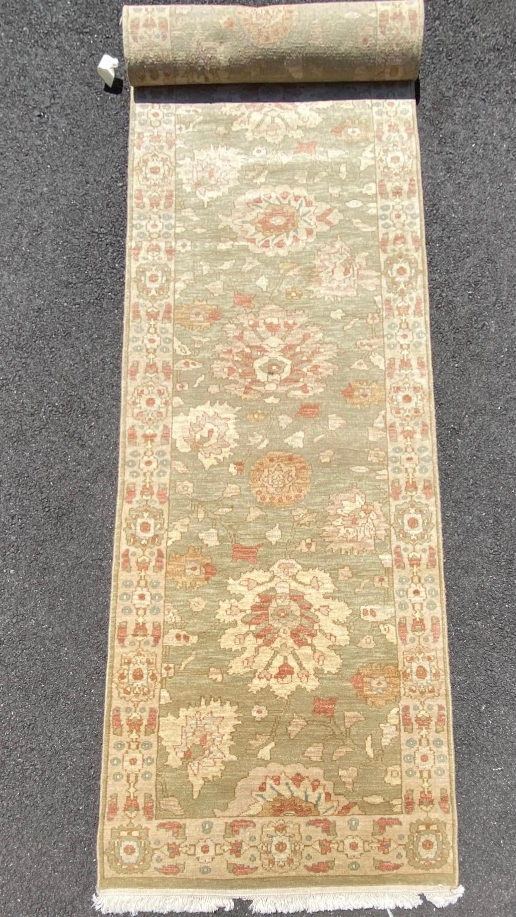 This is a new late 20th century green ivory floral Persian style narrow runner rug handwoven in Alexandria, Egypt in 1990s. We manufactured these rugs and the design and colors were hand chosen by us and we have a wide variety of sizes in this