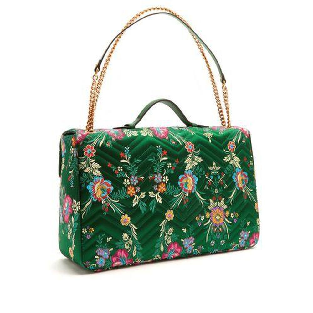 This emerald-green chevron-quilted satin style is patterned with a multicoloured floral jacquard, and embellished with an iconic antiqued gold-tone metal GG plaque on the front flap. The bubblegum-pink satin-lined interior hosts a zip-fastening