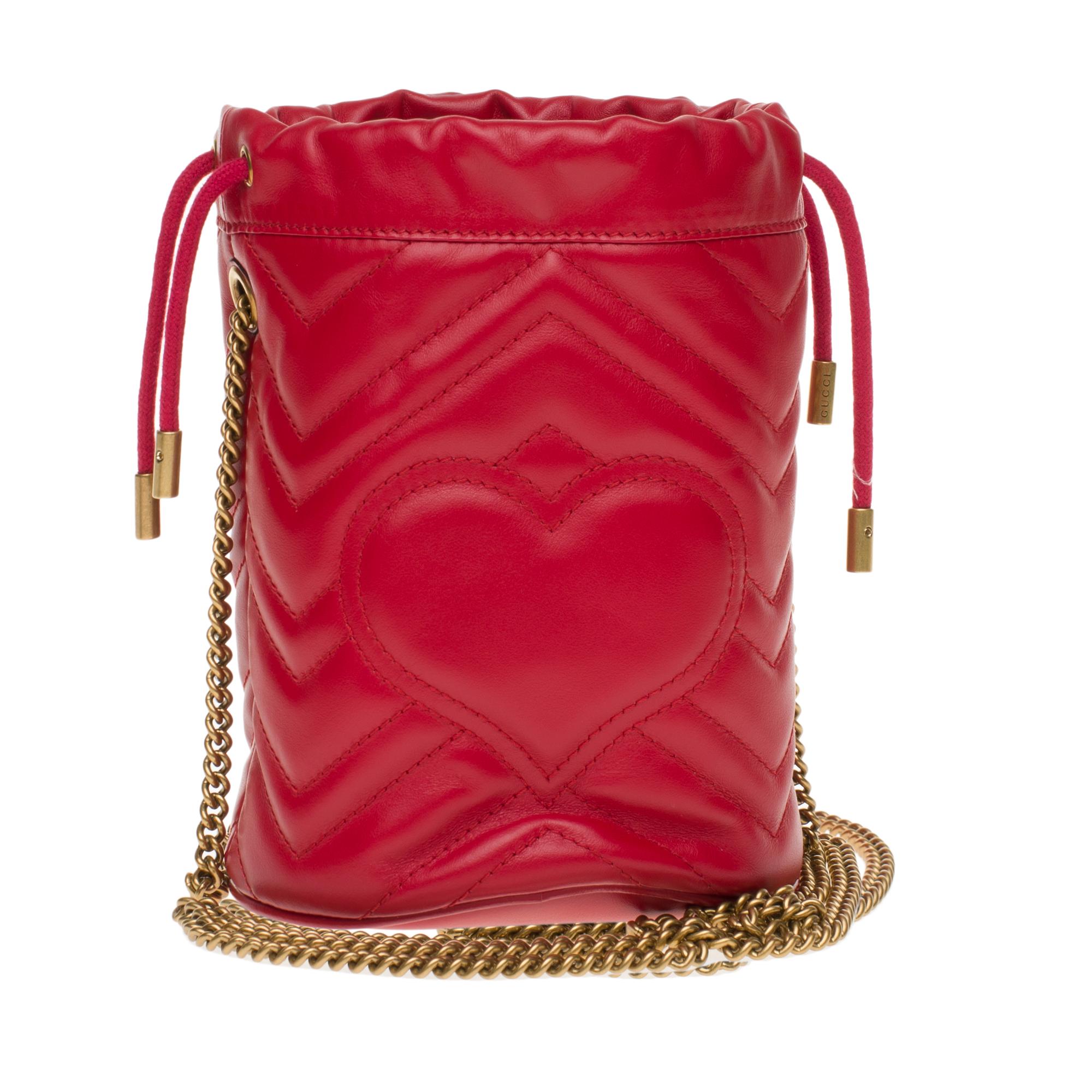 Gucci mini bucket bag GG Marmont made in red quilted leather with chevrons. Inspired by a model from the archives of the 70’s, a flagship period for the House, the Double G adorns the front of this accessory. With its chain shoulder strap and