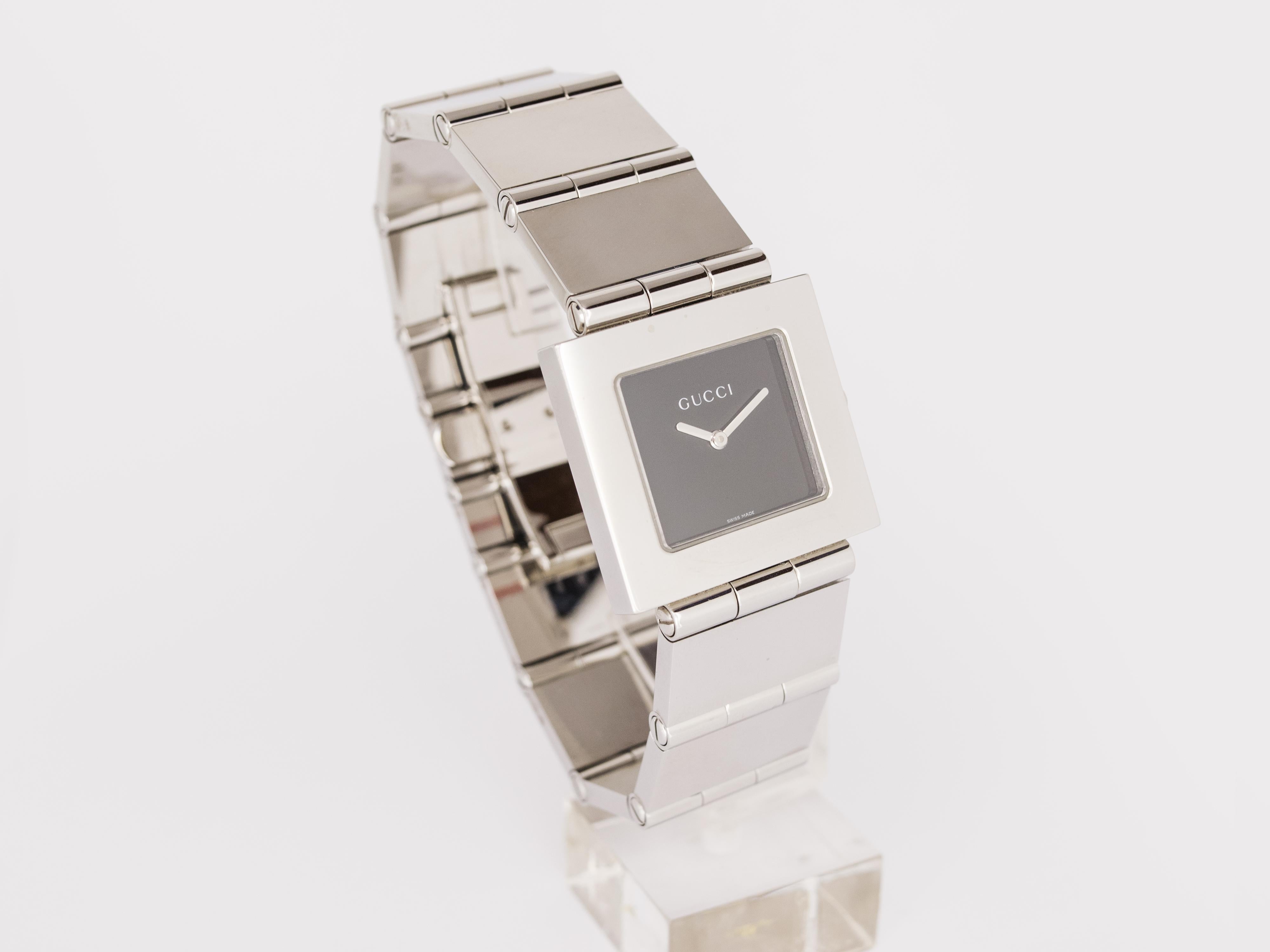 NEW Gucci stainless steel quartz watch Swiss Made.
La montre n'a jamais été portée et provient d'un revendeur agréé italien avec boîte et garantie internationale.

Elle est équipée d'un cadran carré noir brillant sans index.

Le bracelet en acier