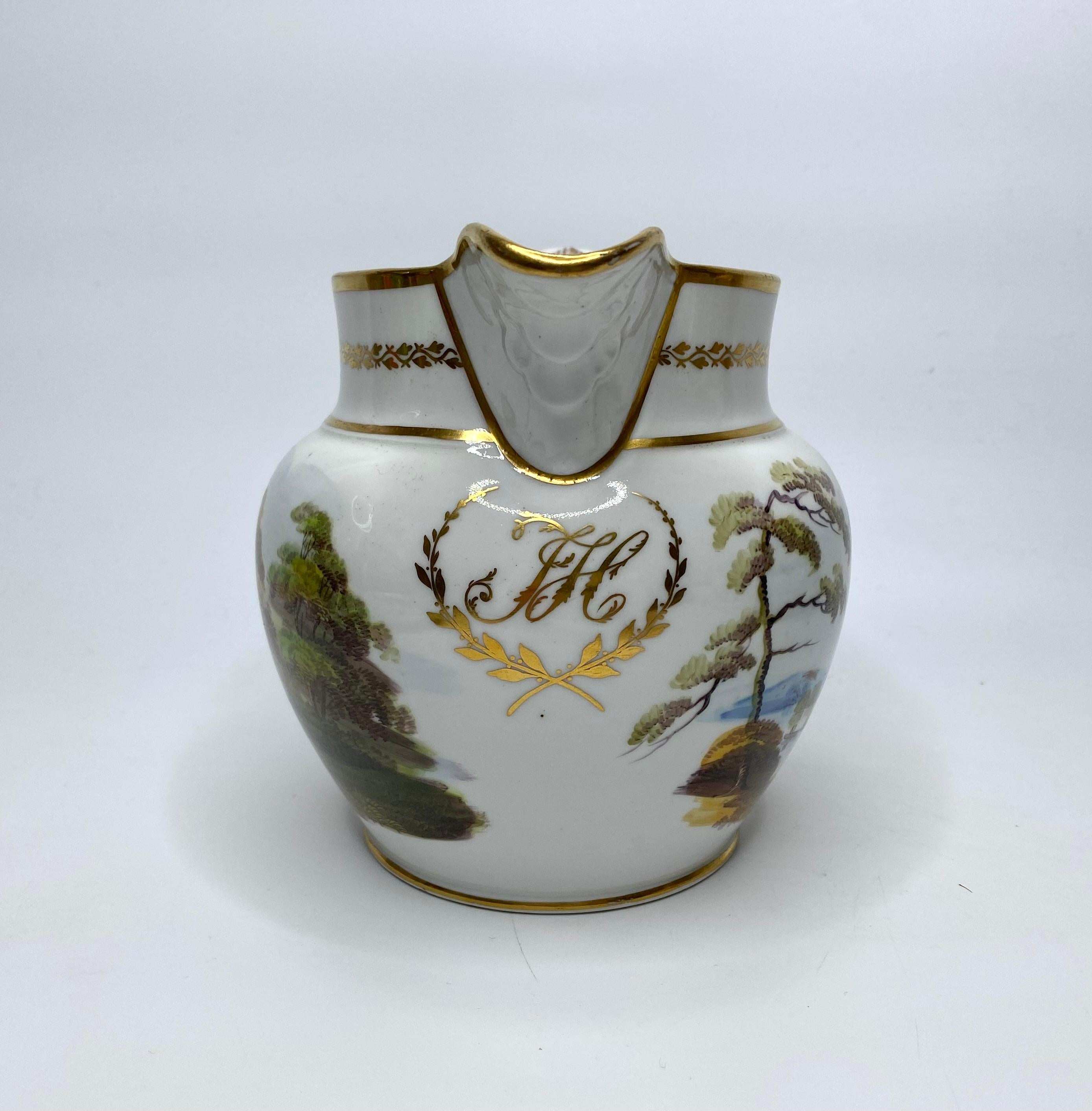 A New Hall bone china ‘Water jug’, c. 1815. The bulbous jug, well painted to one side, with a man riding a horse along a country track, beneath trees. The reverse with a ruined castle in a Lakeland setting.
Having a gilt monogram ‘JH’, within a