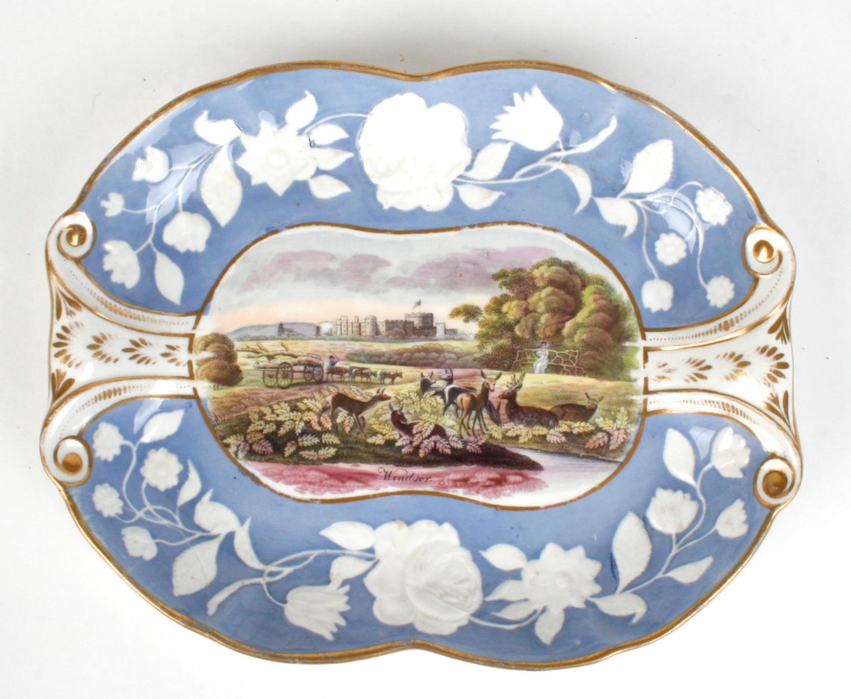Three English new Hall Pâte-sur-pâte serving pieces with British scenery. Each has a raised floral boarder in blue and white trimmed with gilt accents. The scenes include Windsor Castle, Bush Kill Park and View from Greenwich to Stepford. Newhall