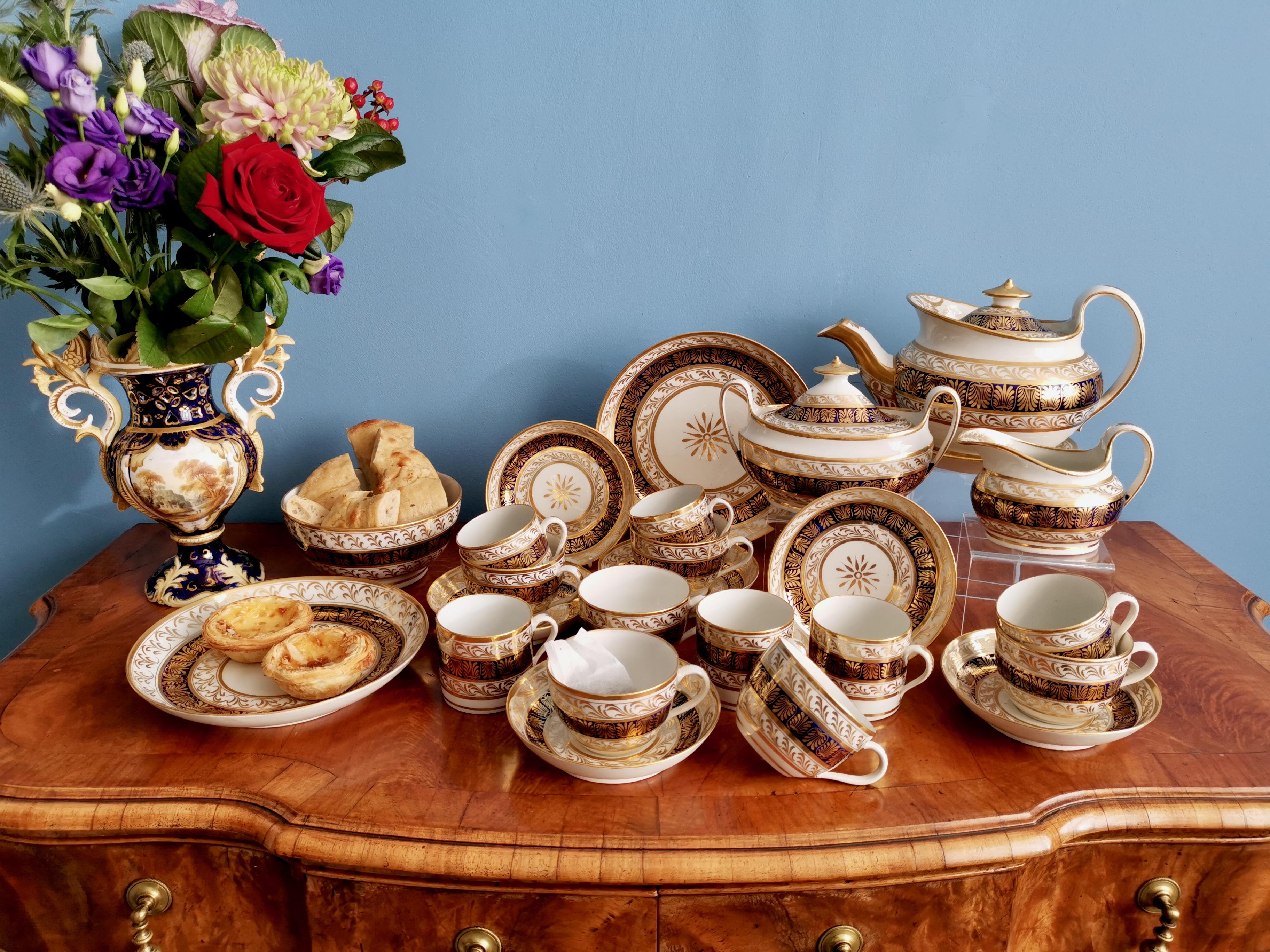 This is spectacular full tea service made by New Hall around the year 1810. The service consists of a lidded teapot on a stand, a lidded sucrier, a milk jug, six teacups and saucers, six coffee cans, two large cake plates of different sizes, and a