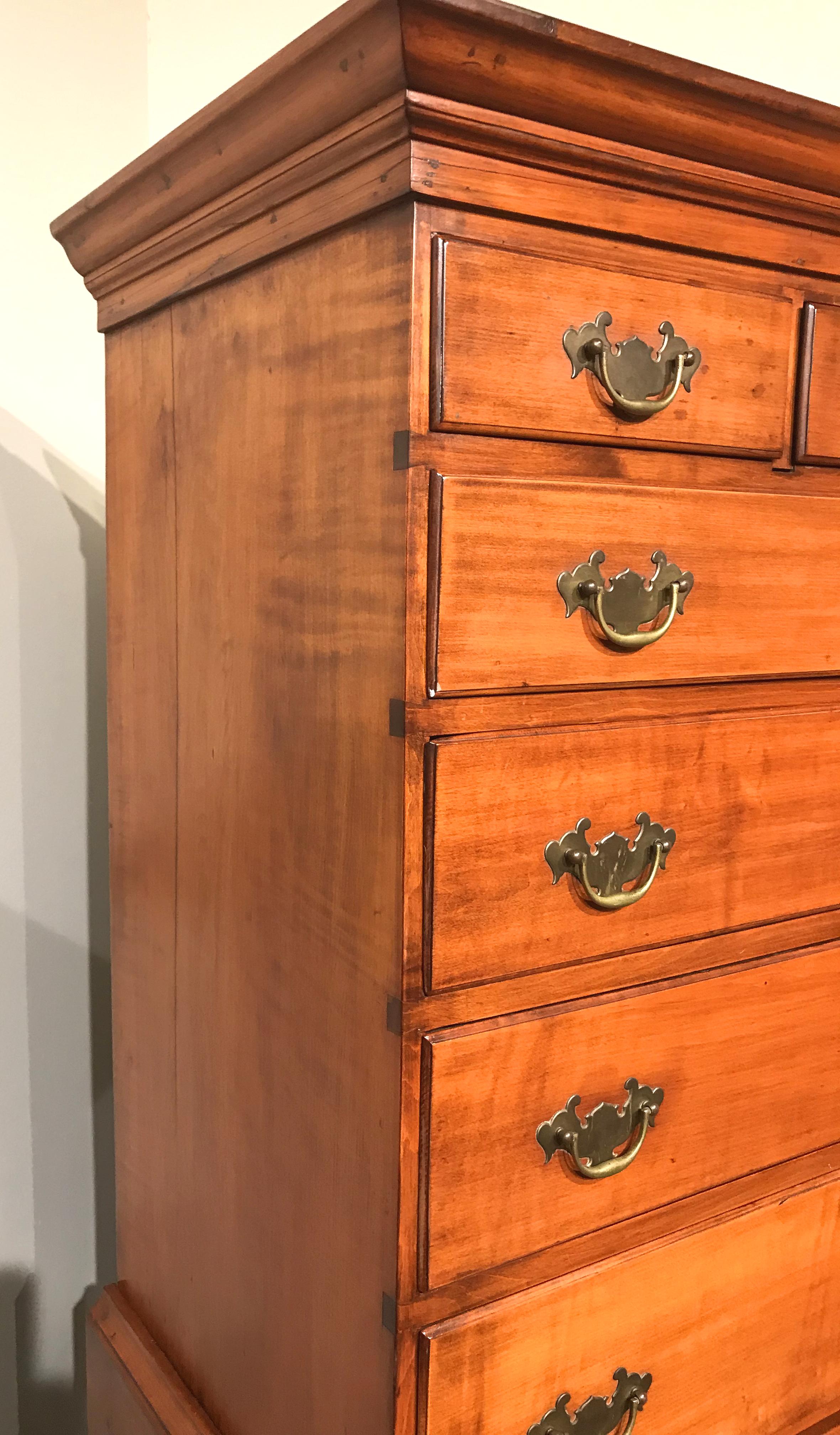 A fine two part New Hampshire Dunlap School tiger maple highboy or chest on chest, its upper case with a molded cornice surmounting three short drawers over four graduated long drawers, all resting on a lower case with three graduated long drawers,