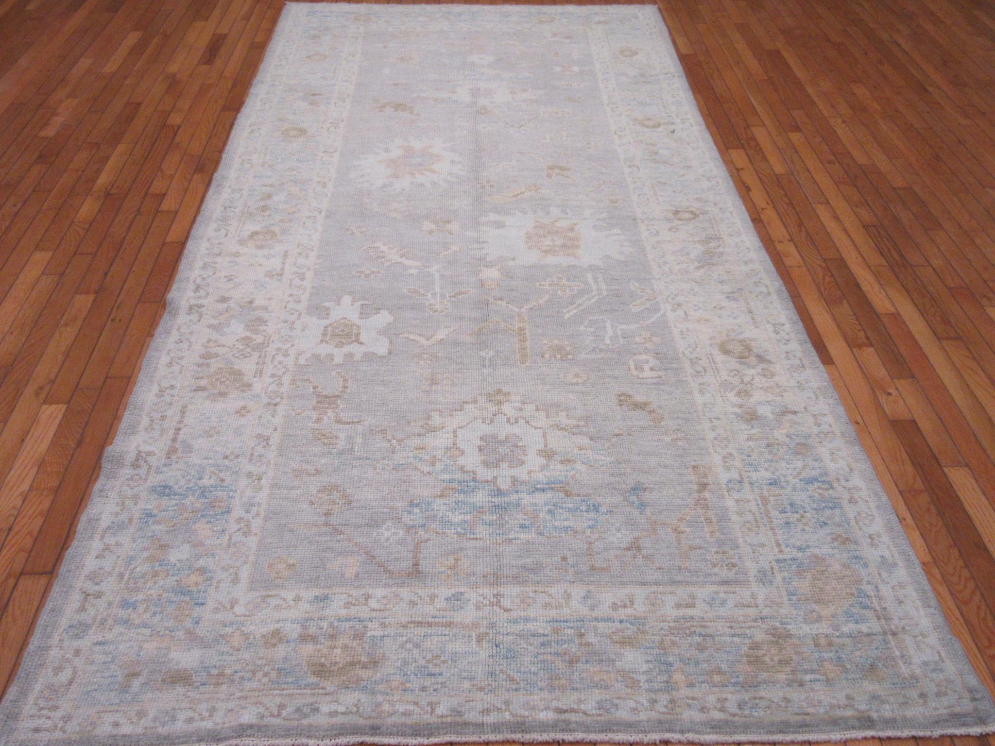 This is a new hand knotted wide and long Turkish Oushak runner rug. It is made with wool pile and wool foundation dyed in today's colors of mainly gray and blue. It measures 5' 4'' x 11' 7''.