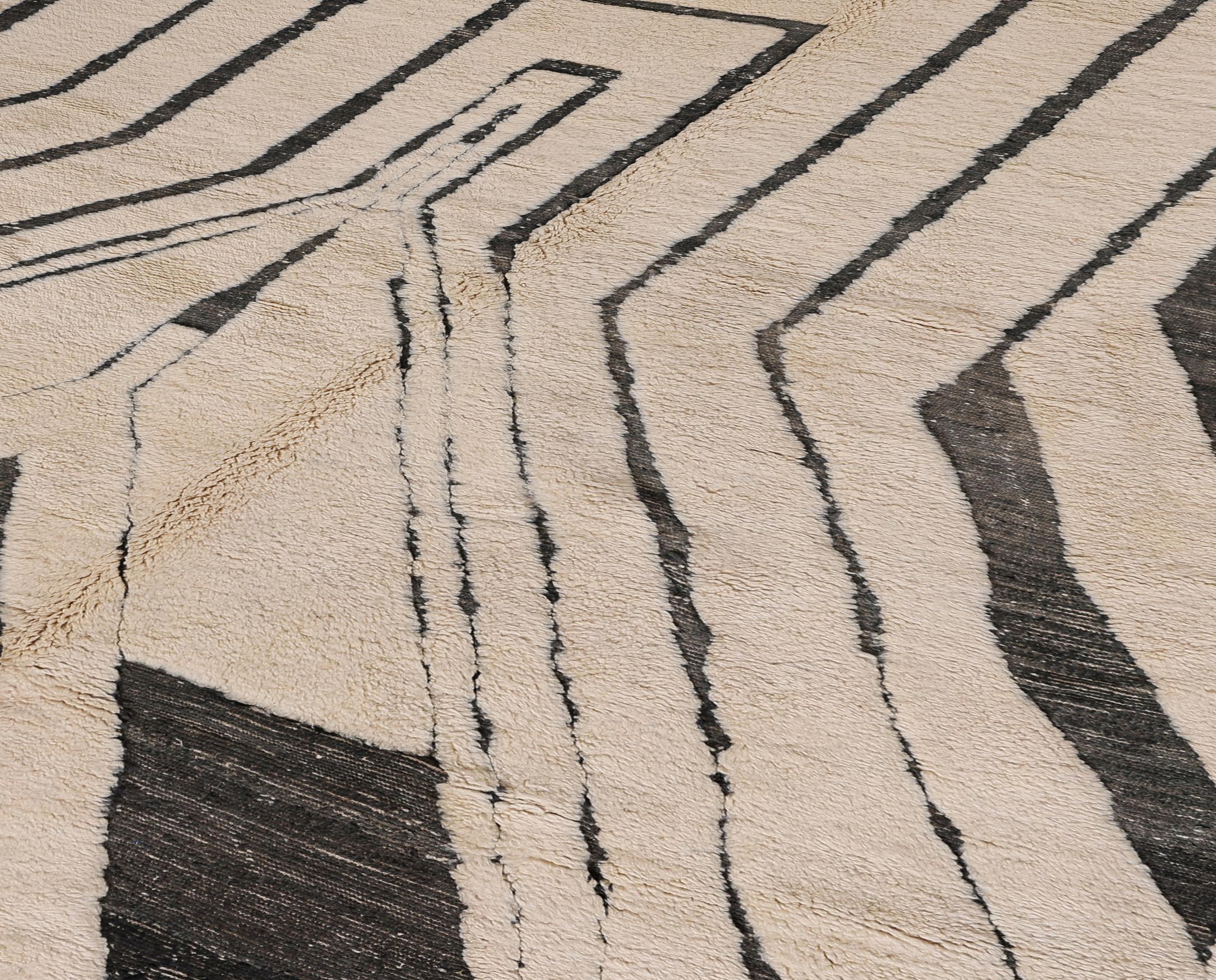 Elevate your space with this newly made Moroccan rug, expertly hand-knotted by master artisans using natural wool. Featuring a bold geometric pattern in black against a soft cream background, the design evokes architectural rhythm and modernist