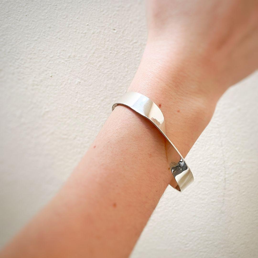 Eleva il tuo stile con il bracciale Kawsay, un pezzo elegante e sofisticato realizzato a mano in argento 925. Caratterizzato da un design minimalista, questo bracciale fonde perfettamente l'estetica contemporanea con un'eleganza senza tempo,