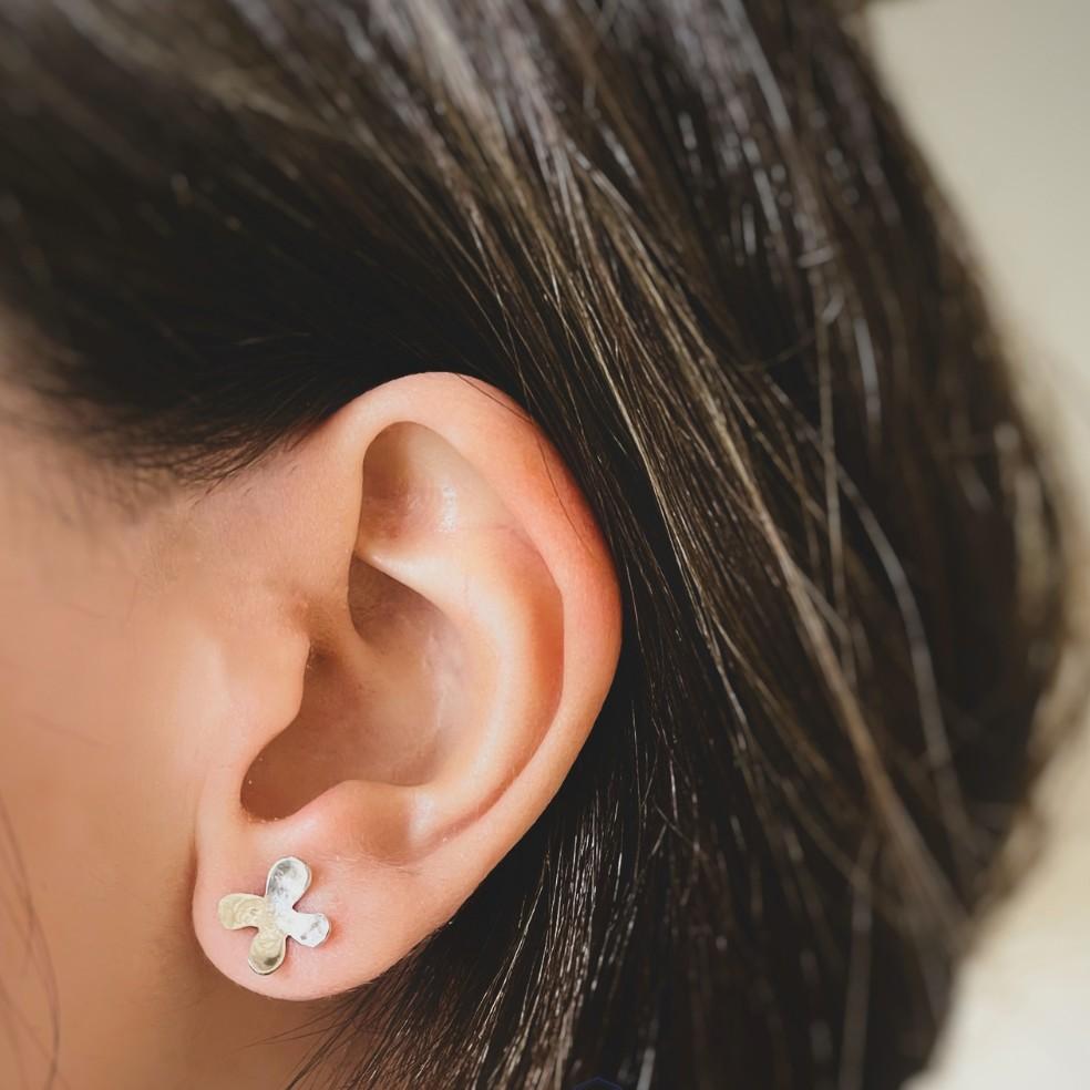 Ces boucles d'oreilles artisanales sont fabriquées en argent massif 925 et présentent un délicat motif de fleur à quatre pétales, symbolisant la simplicité, l'harmonie et la beauté naturelle. De petite taille mais pleines de charme, les boucles