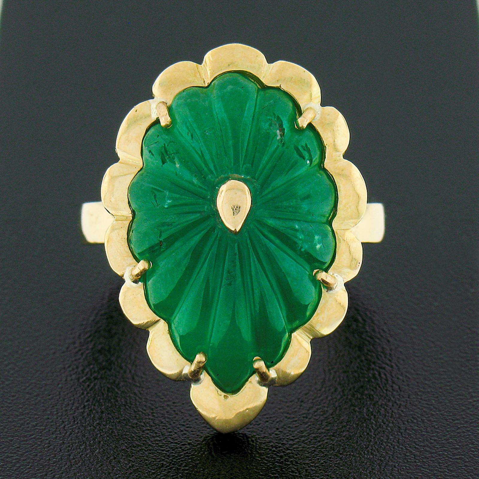 This uniquely custom handmade emerald cocktail ring is very well crafted in solid 18k green gold and features a gorgeous, GIA certified natural emerald stone that's neatly set at the center of a scalloped setting that beautifully traces the carving