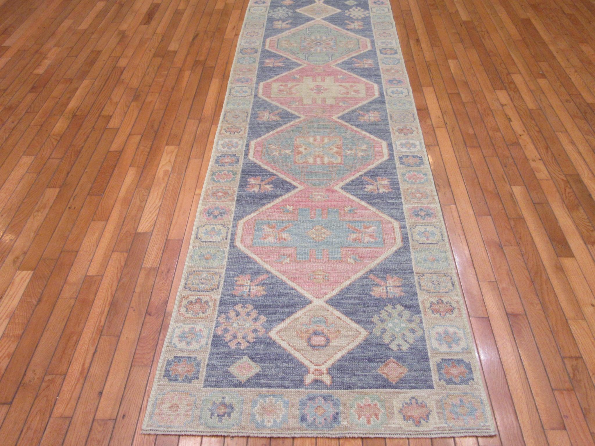 This is a new hand knotted runner rug from Turkey. It is made with durable Turkish wool in traditional geometric multi medallion Anatolian design. It has the rich updated joyful colors bringing life to any spot or hall. It measures 2' 11'' x 10' 2''.